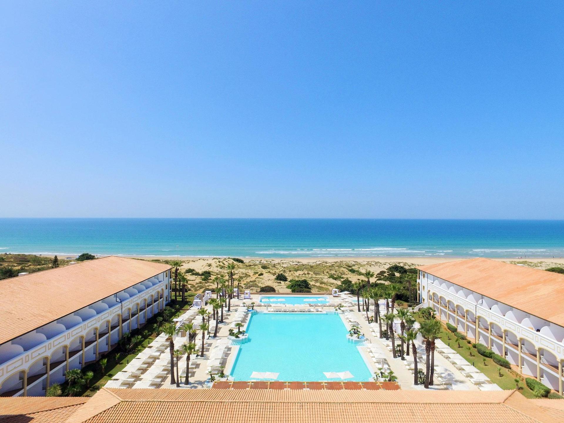 Overhead view of the outdoor swimming pool leading to the beach at Iberostar Selection Andalucia Playa