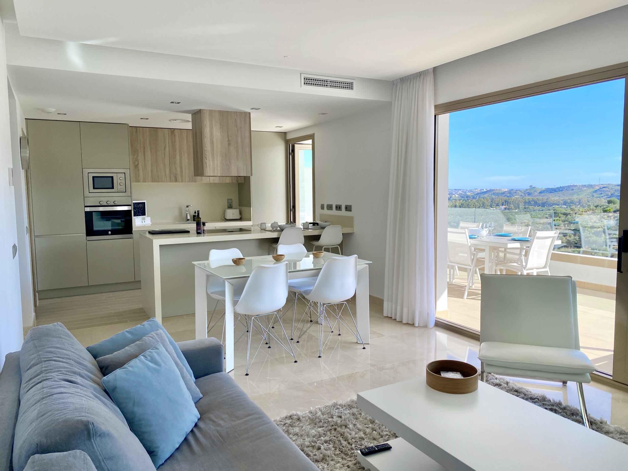 Living room and kitchen with balcony views from an apartment from La Cala Golf Resort - Rentals