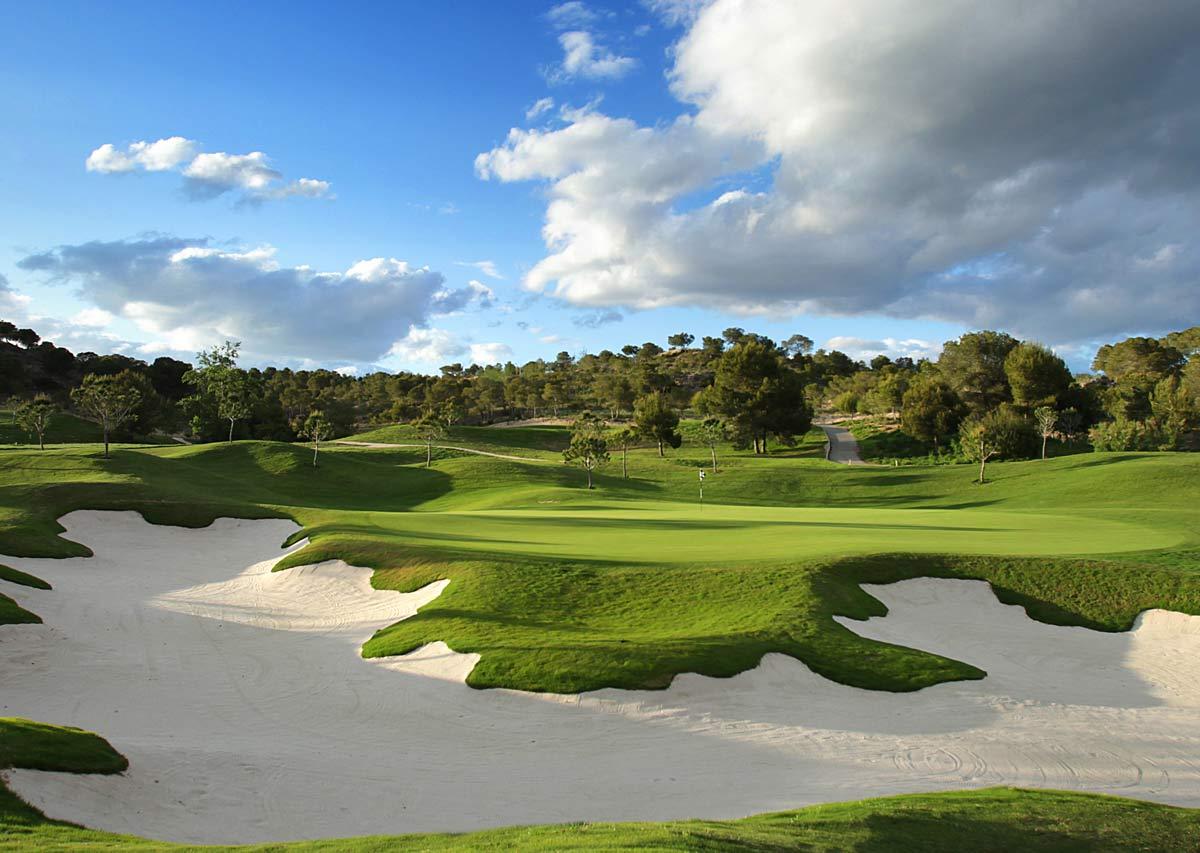 Large bunker in front of the green with trees in the background