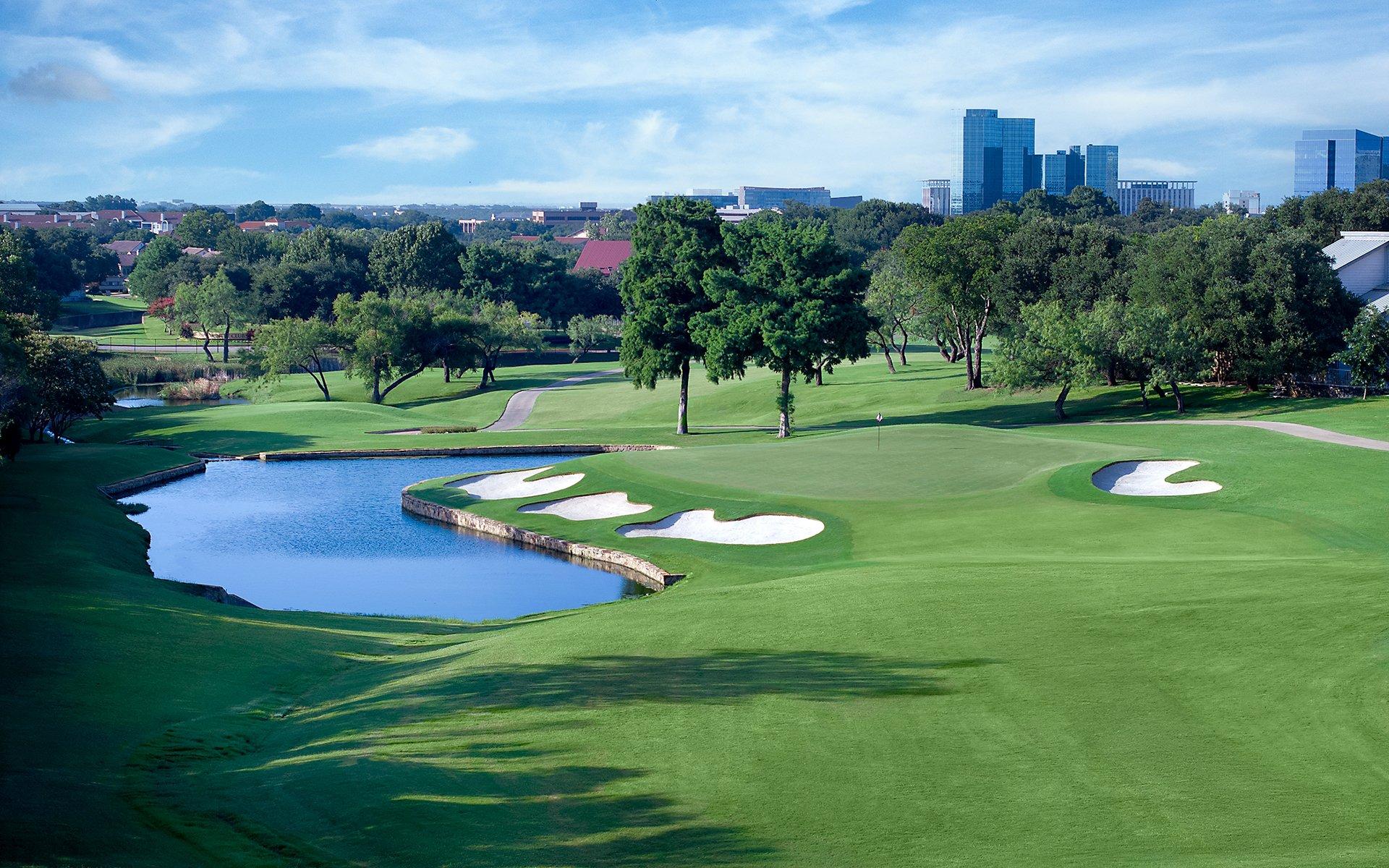 Aerial view of the green with bunkers around it and a water hazard to the side