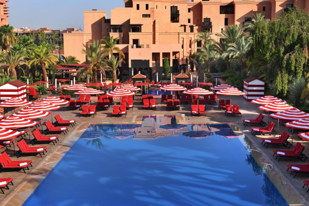 Overhead view of the outdoor swimming pool surrounded by sunbeds at Movenpick Mansour Eddahbi Hotel