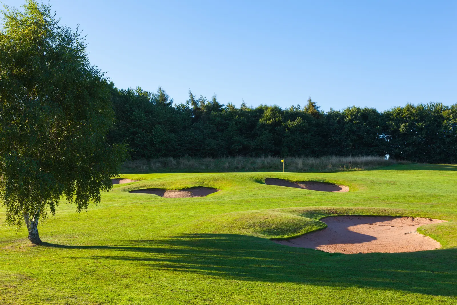 A wide fairway nestled with sand bunkers
