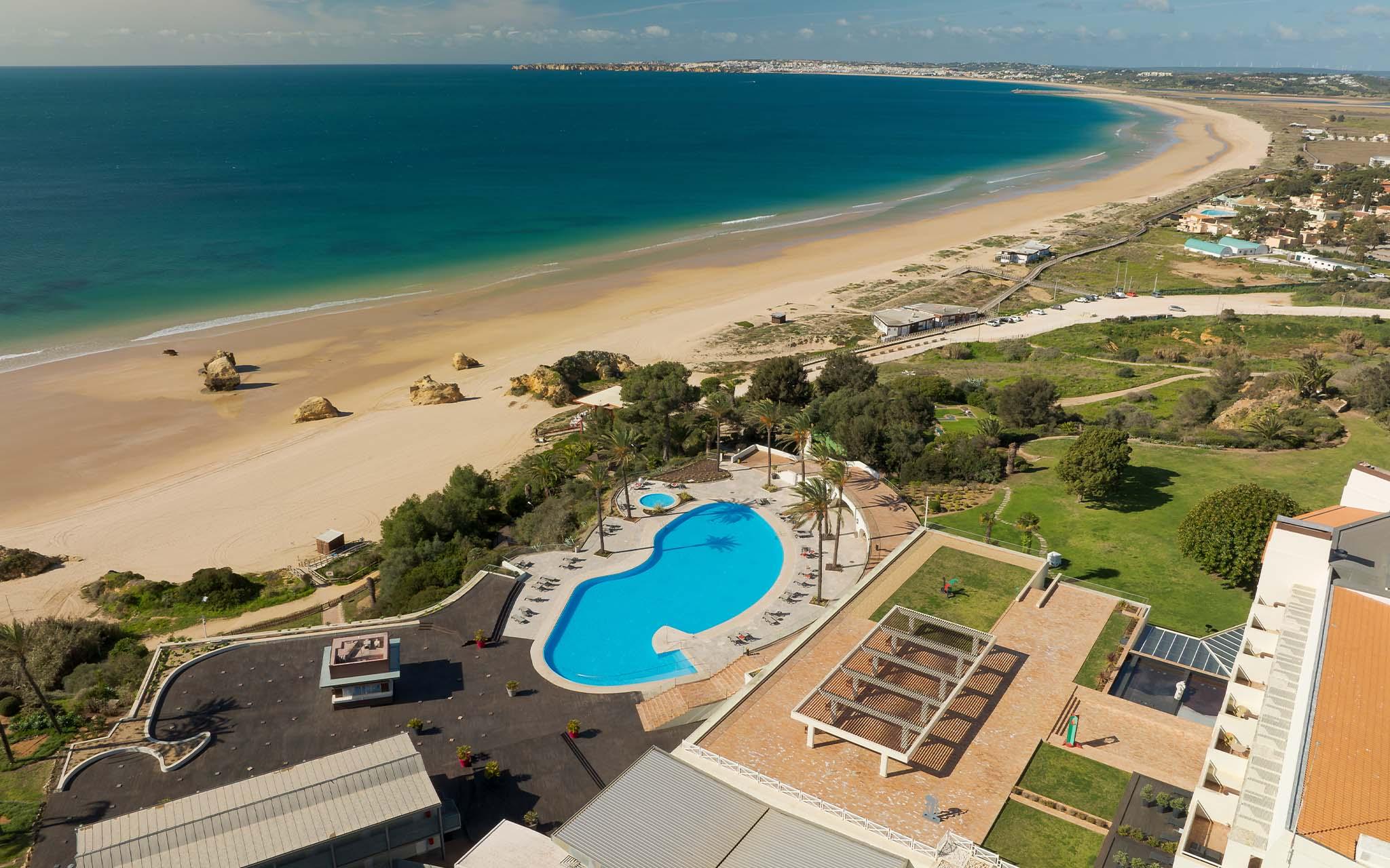 Overhead view of the outdoor swimming pool leading to the beach at the hotel