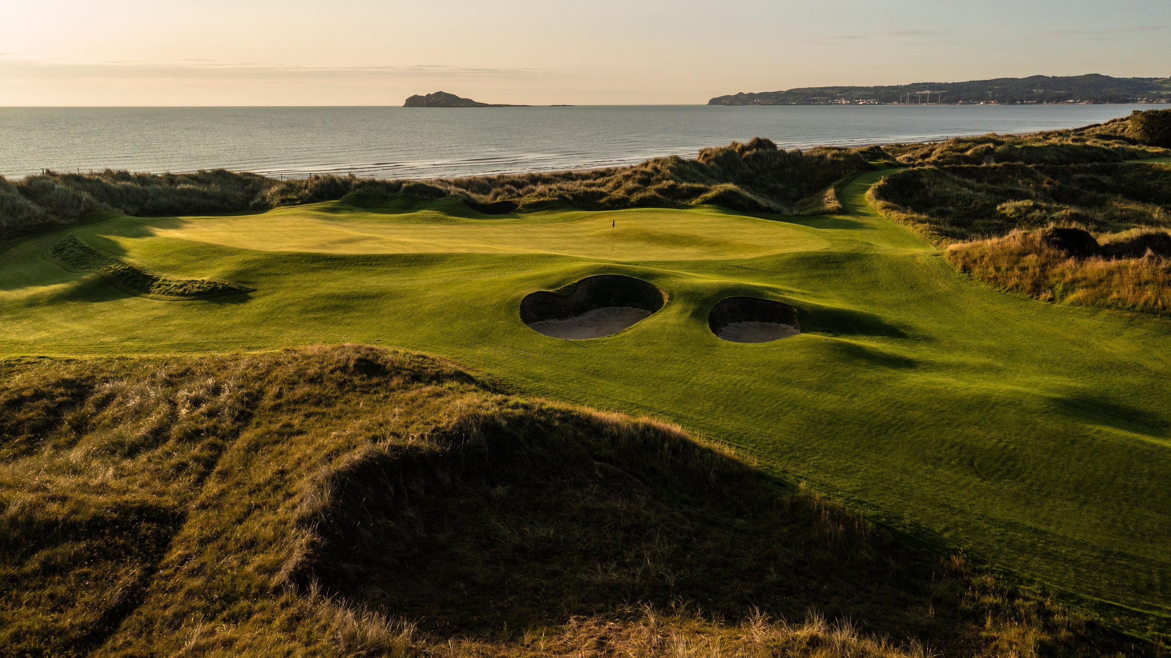 A coastal green surrounded by sand bunkers at the Portmarnock Resort & Jameson Golf Links