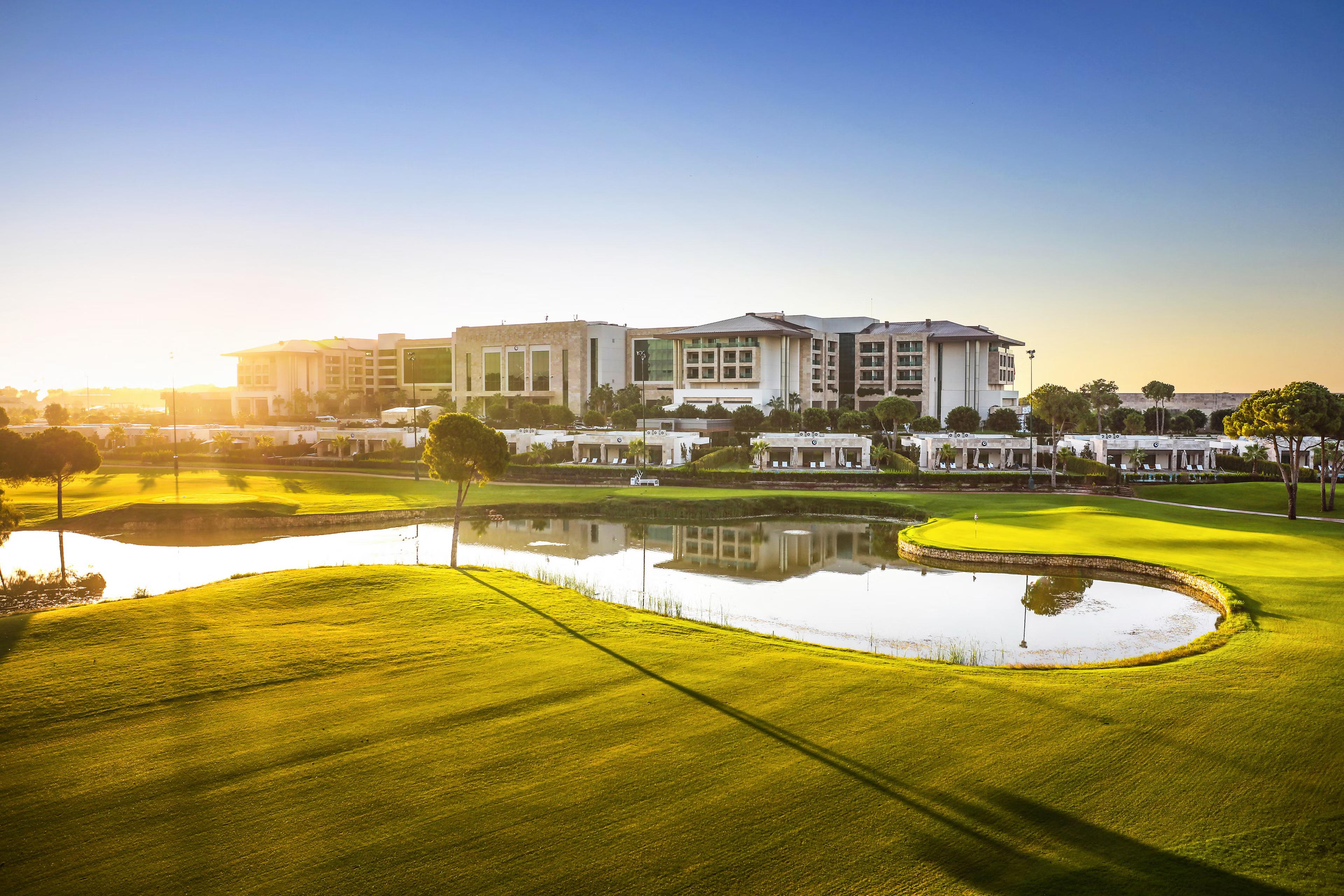 A well maintained fairway next to a water hazard under the sun