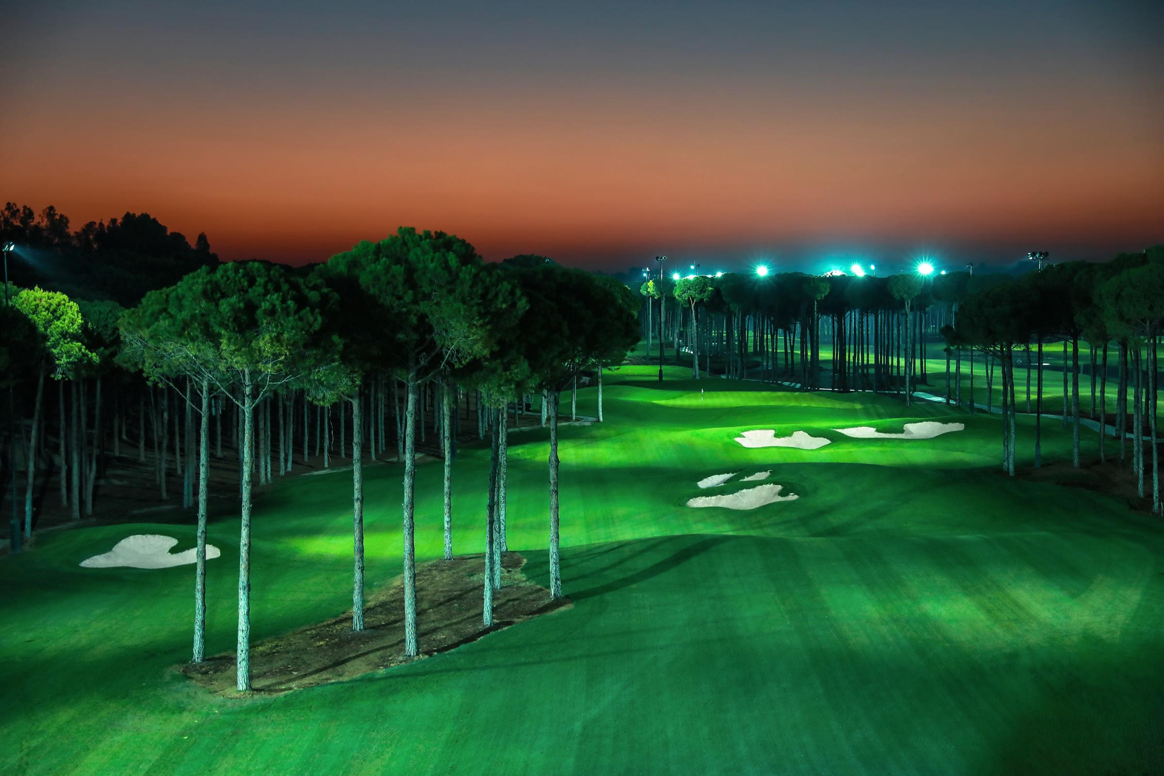 A well maintained fairway nestled with sand bunkers on the night golf course