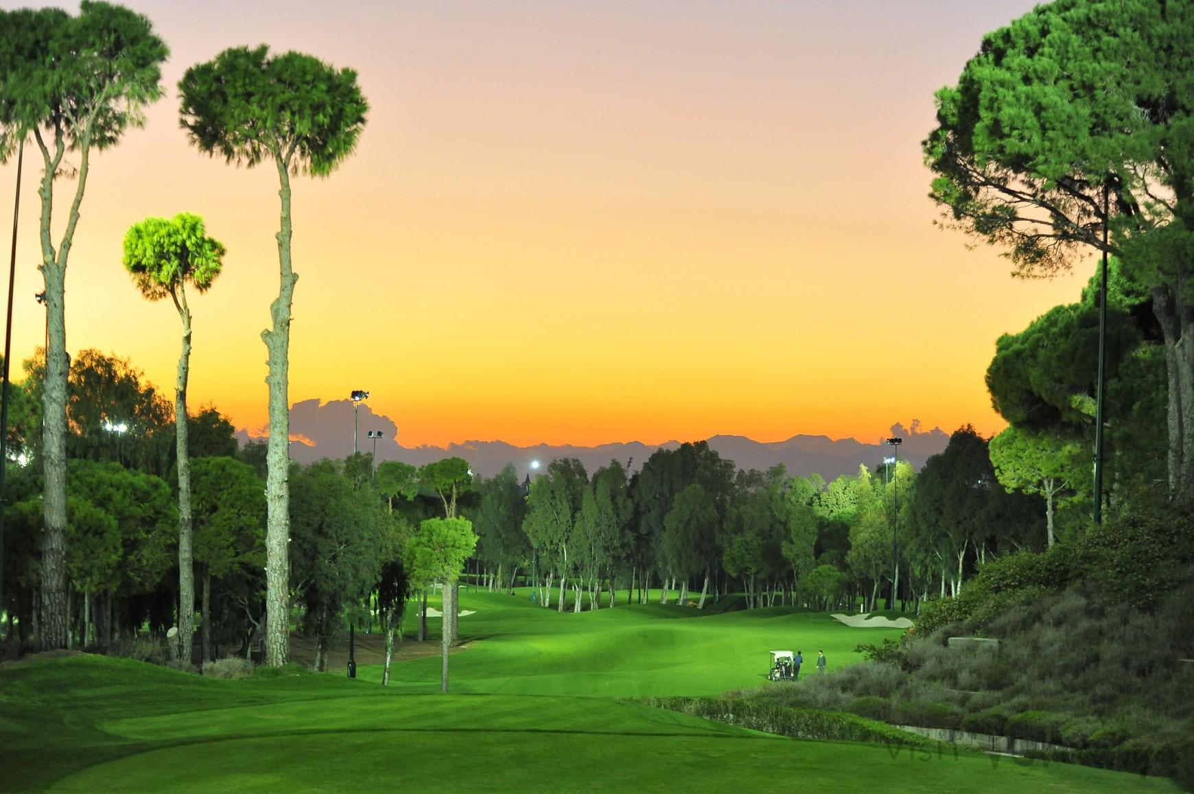Sun setting over the night golf course at Regnum Carya Golf & Spa Resort