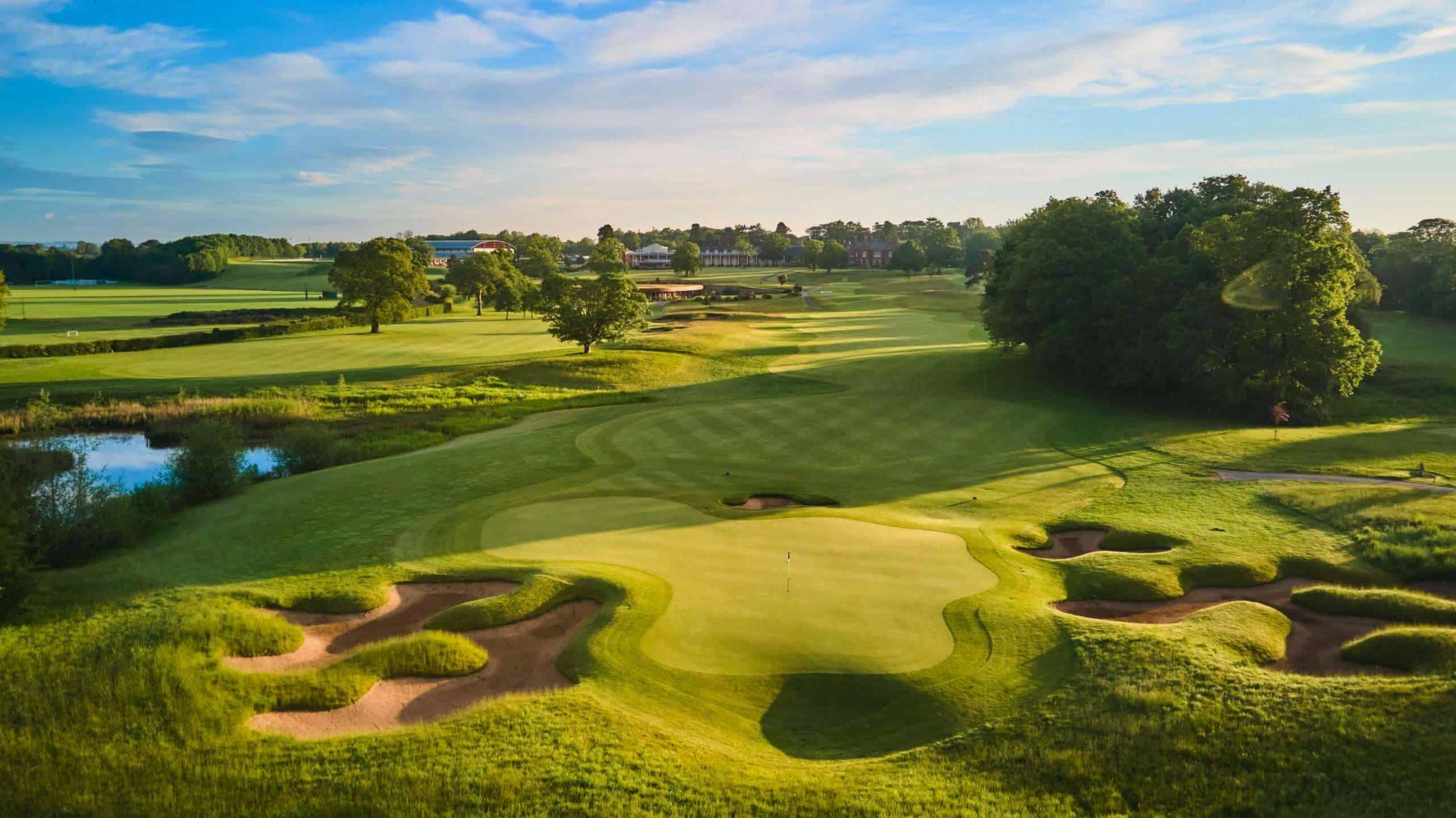 Overhead view of a smooth green next to a uniquely shaped snad bunker