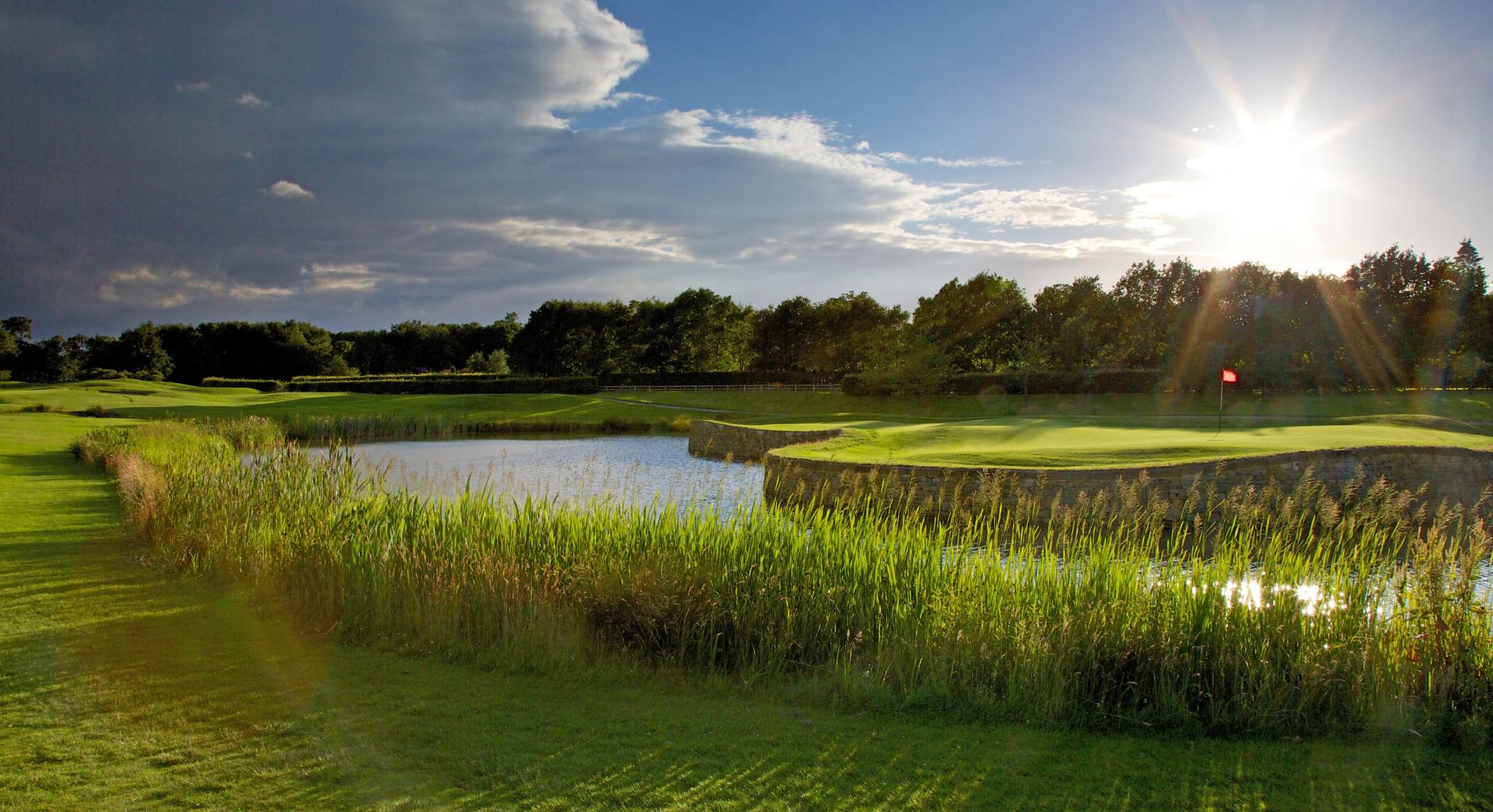 A well maintained fairway running besides a water hazard at the Rudding Park Hotel & Golf Club