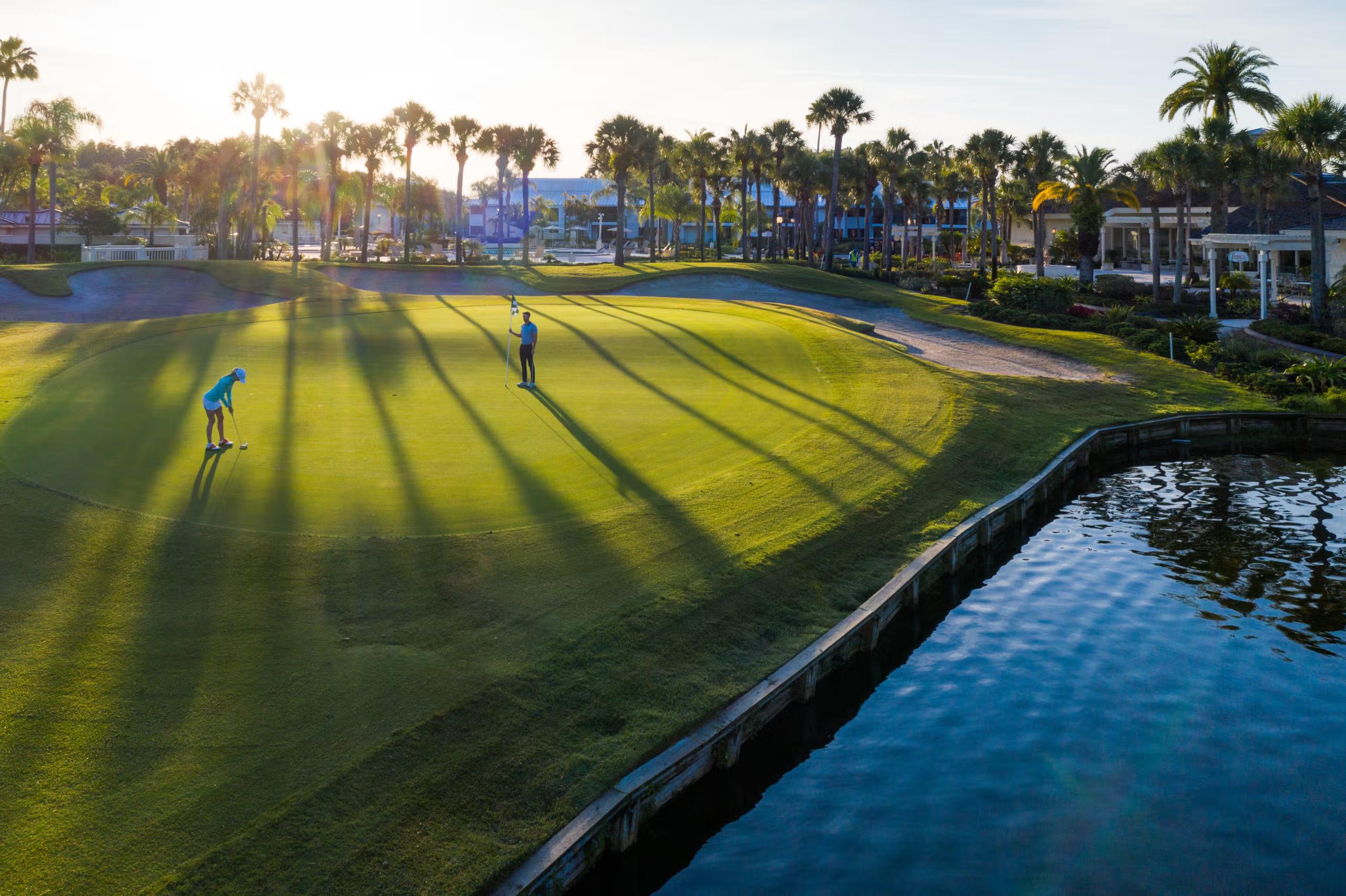Sun shining over a well maintained fairway next to a water hazard at Saddlebrook Resort