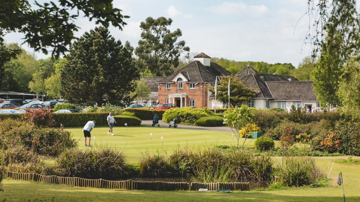 Golfers playing on a manicured green