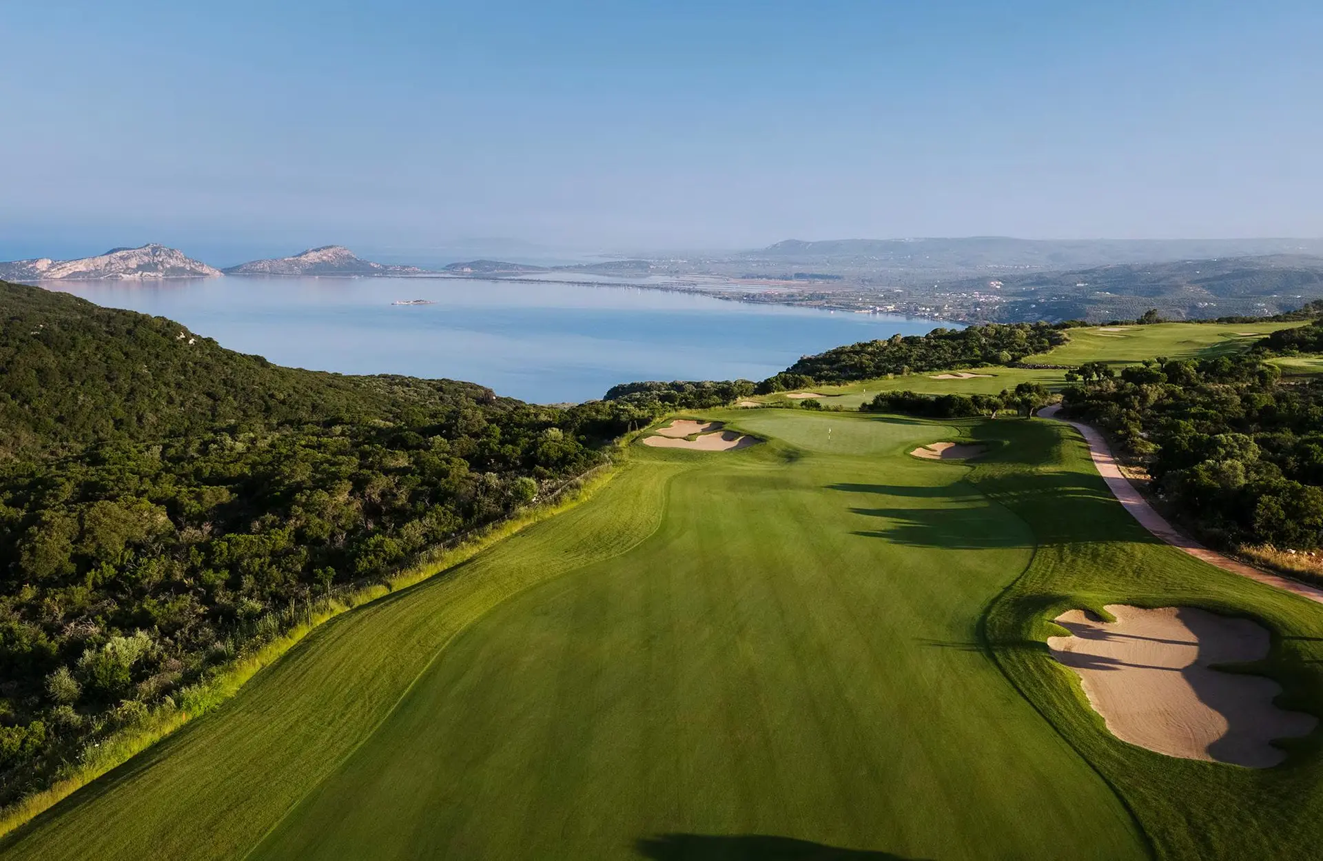 A well maintained fairway nestled with sand bunkers ad ocean views