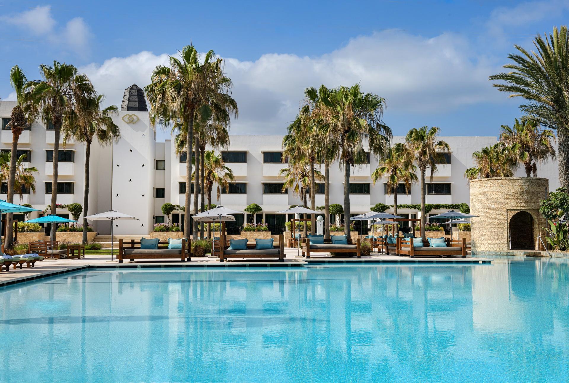 Outdoor swimming pool surrounded by palm trees at Sofitel Agadir Royal Bay Resort