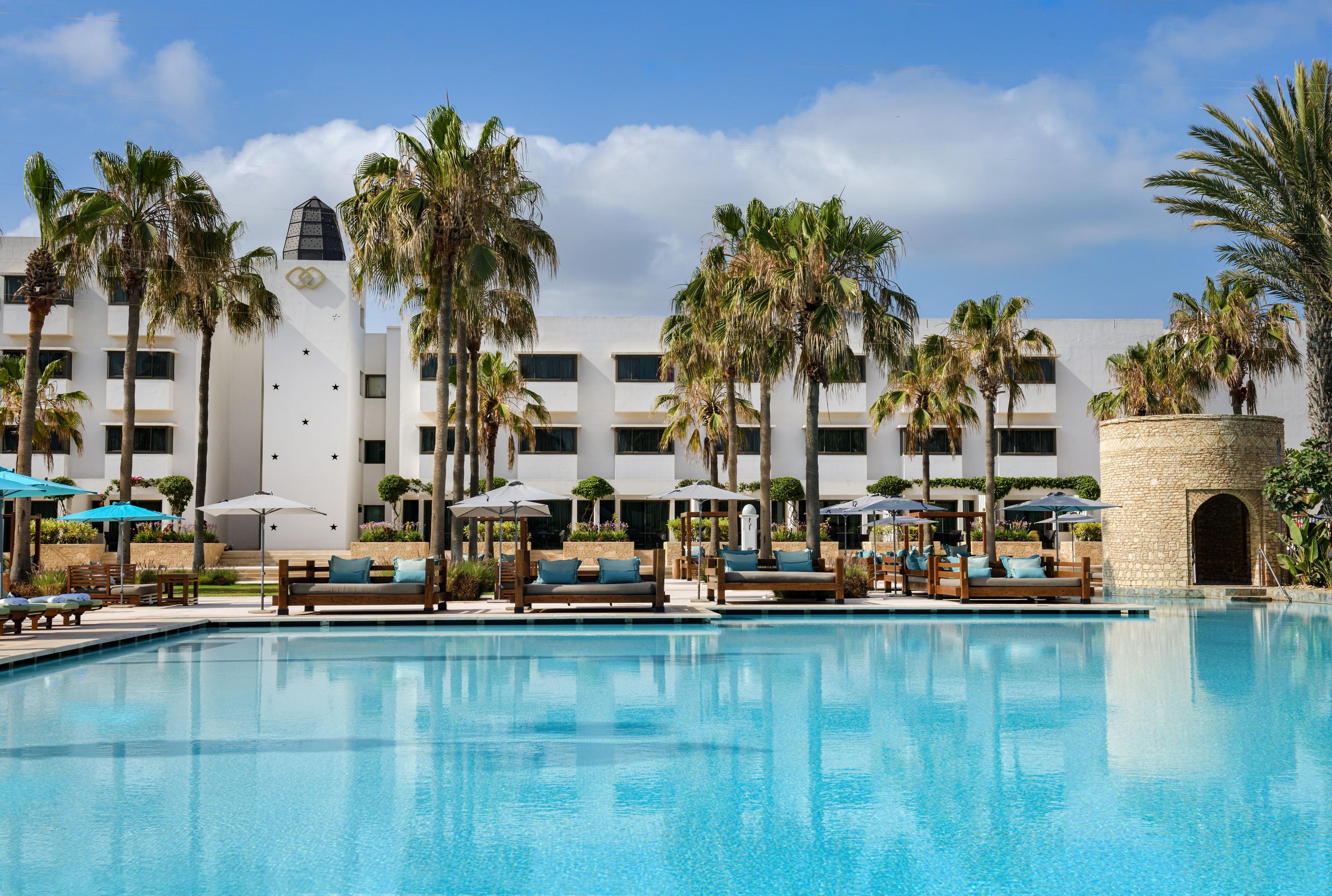 Outdoor swimming pool surrounded by palm trees at Sofitel Agadir Royal Bay Resort