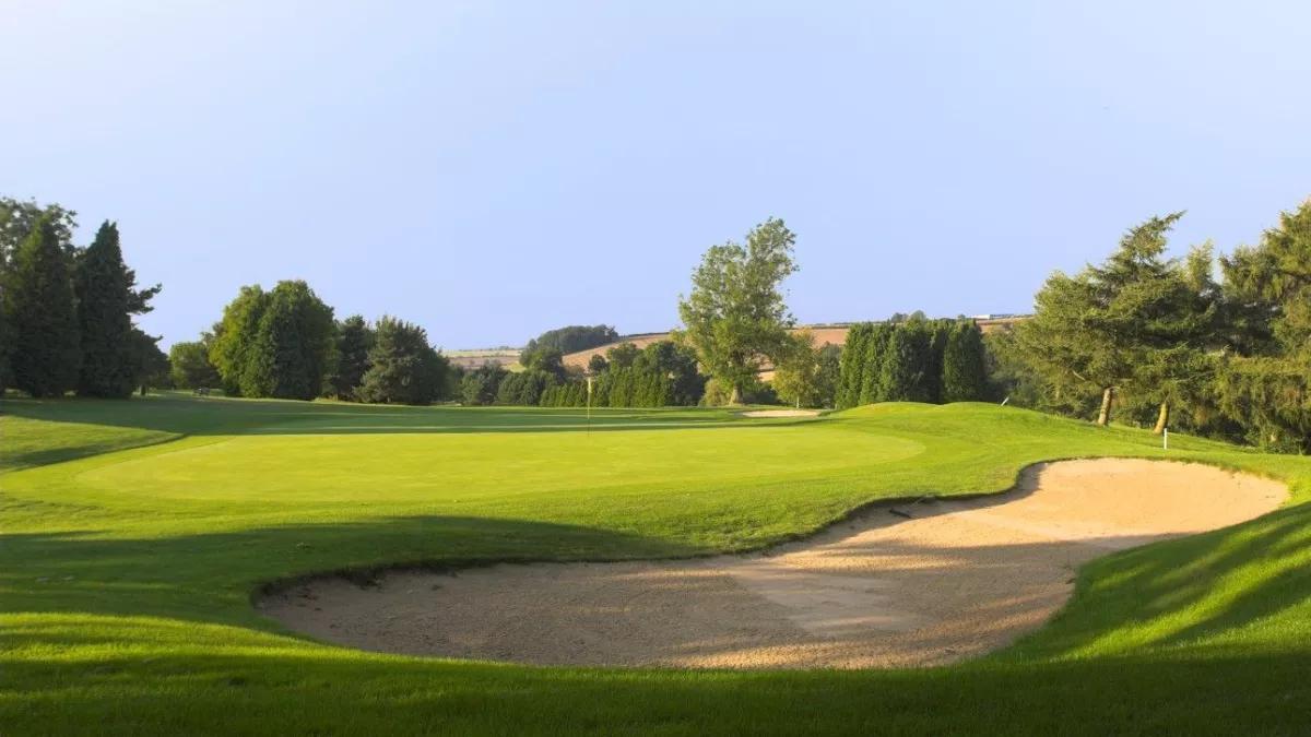 A well maintained fairway nestled with a sand bunker at the Staverton Park Hotel & Golf Club