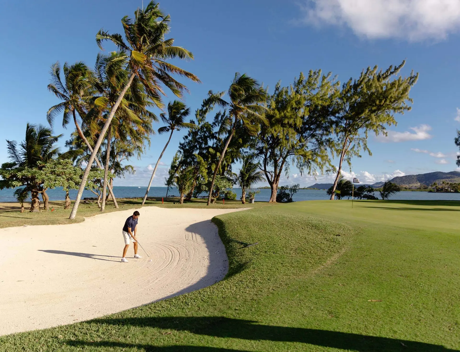 A large sand bunker next to a fairway