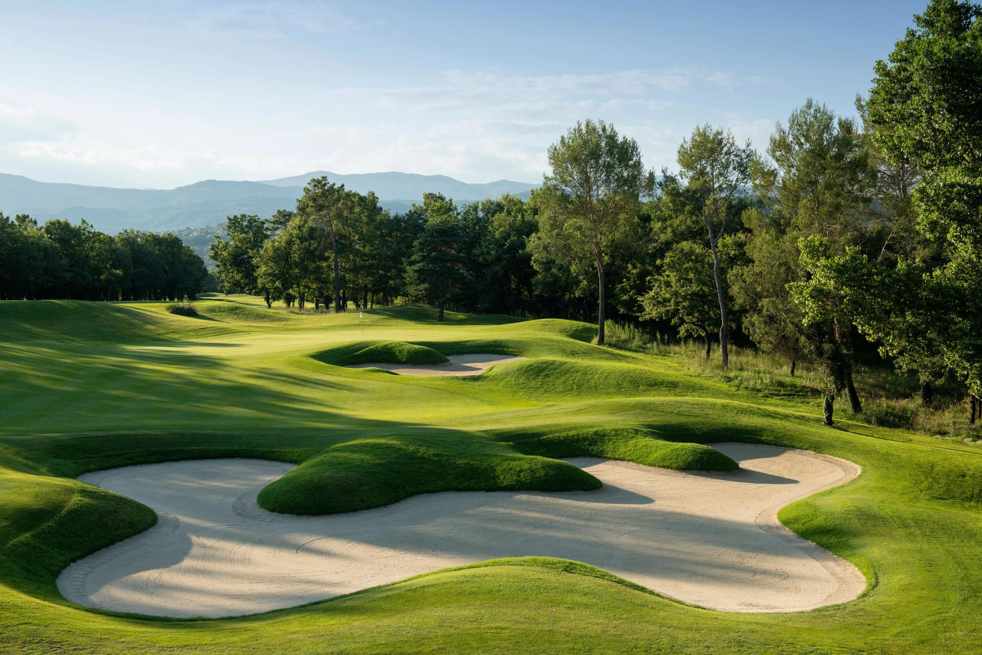 A well maintained fairway nestled with sand bunkers