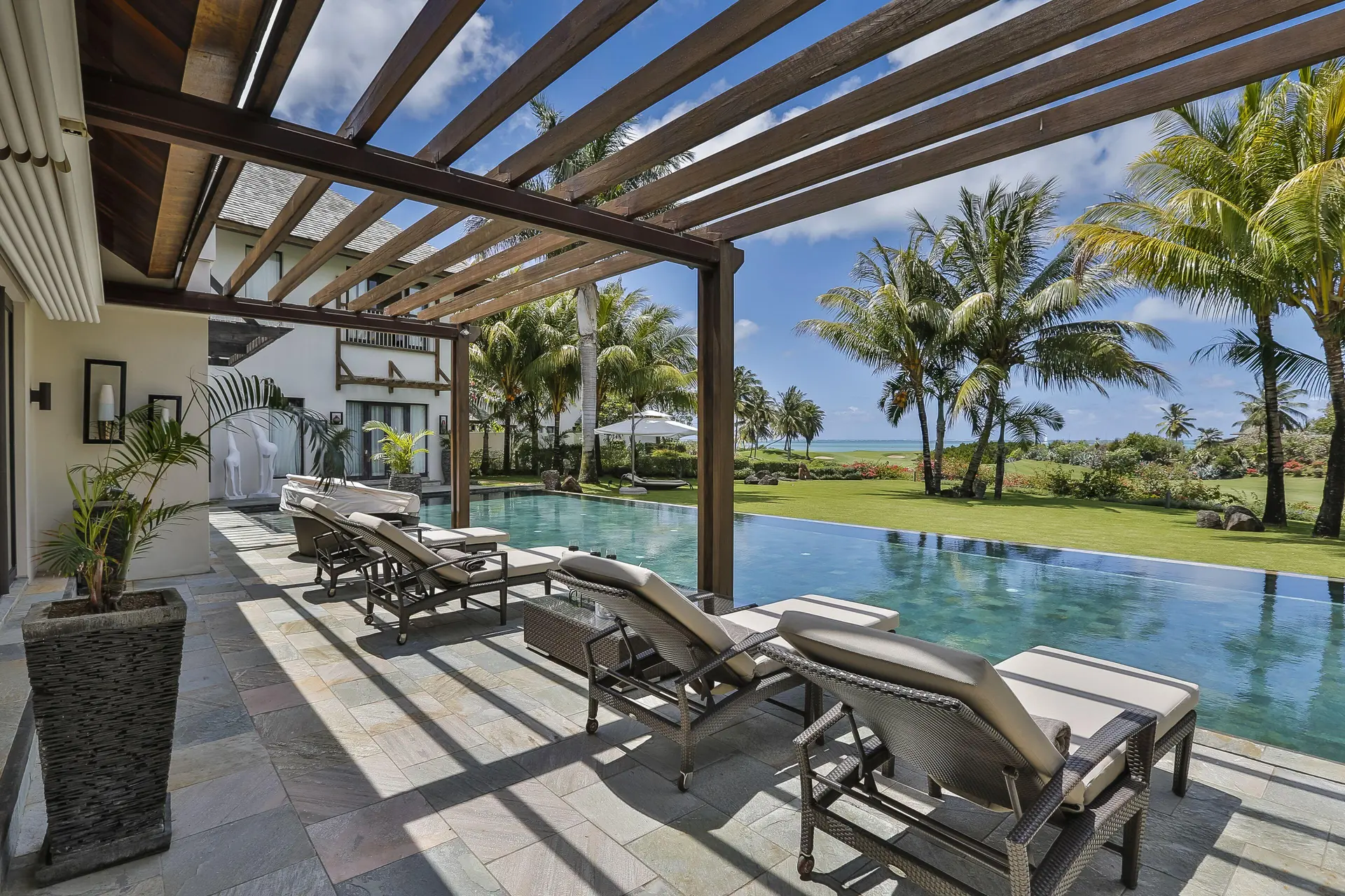 Sunbeds besides an outdoor swimming pool at The Bay Club at Anahita
