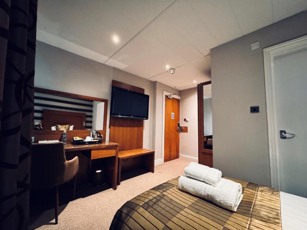 Single bed room with a tv on the wall at The Golf Hotel at Woodhall Spa Hotel