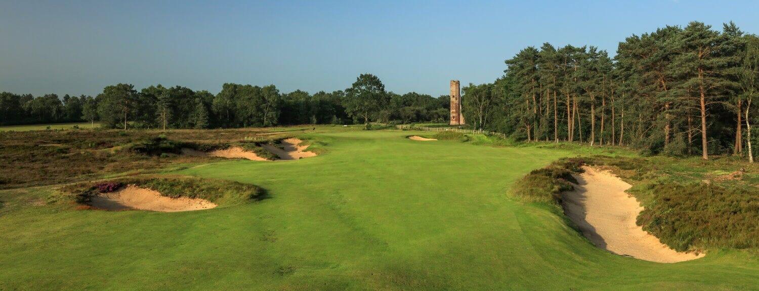 A well maintained fairway nestled with sand bunkers