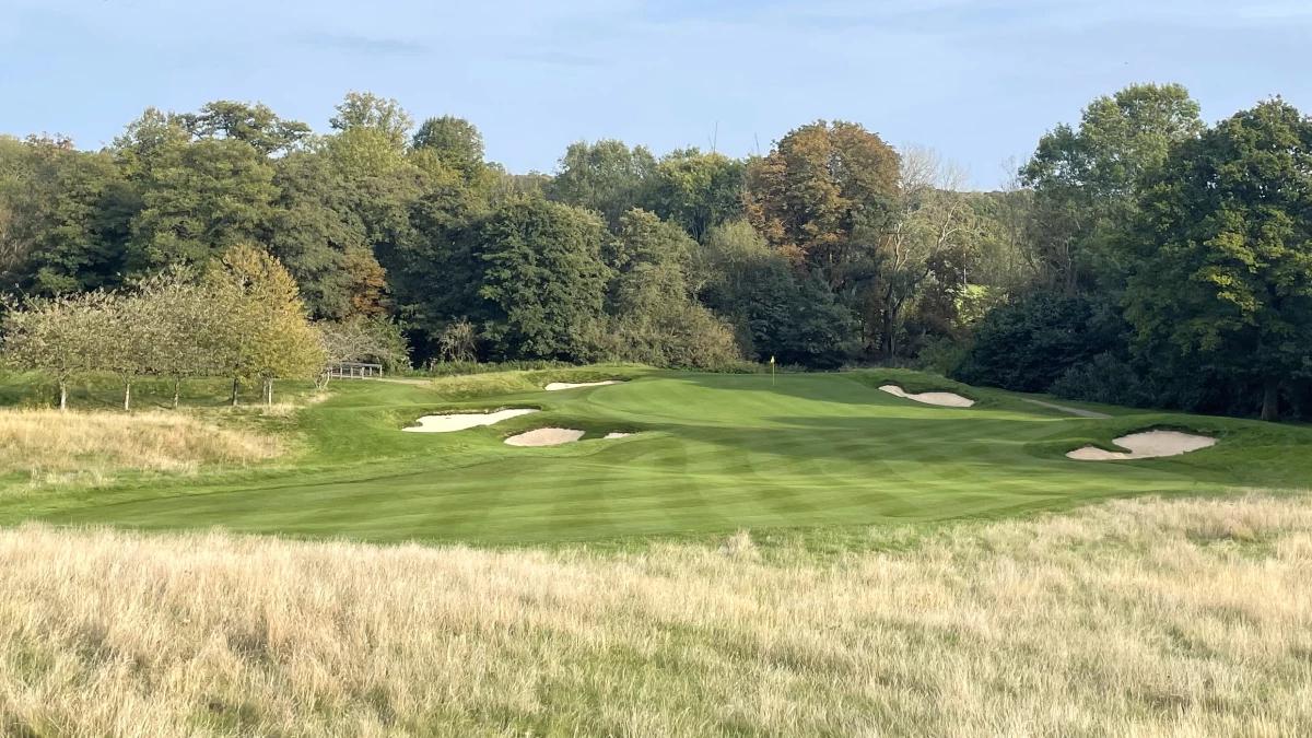 A well maintained fairway nestled with sand bunkers