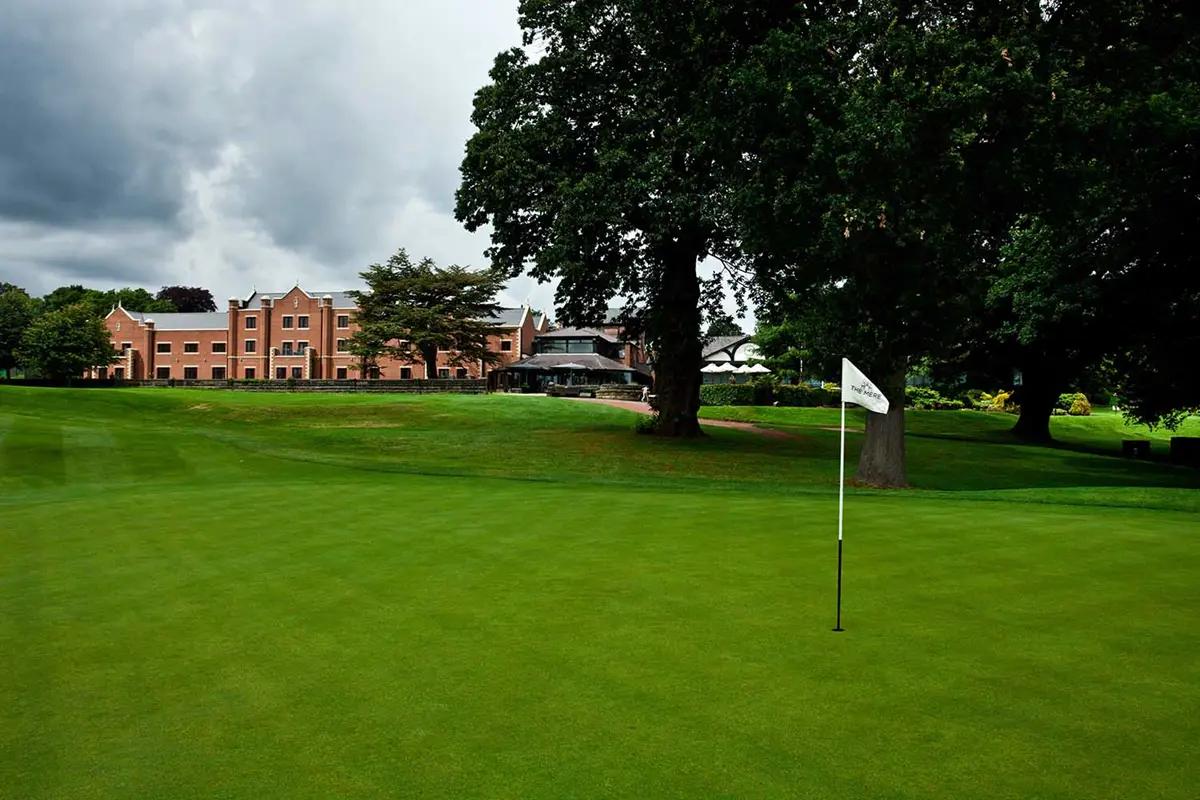 A smooth green with a white flagstick at The Mere Golf Resort & Spa