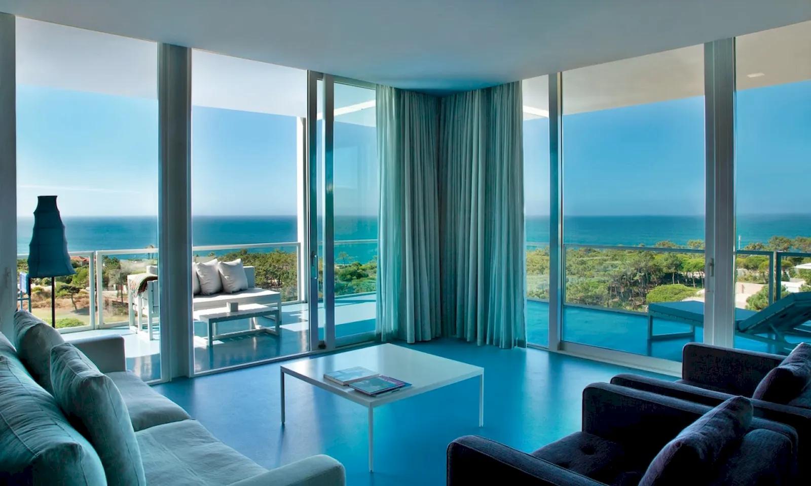 Living room with balcony access as part of a suite at The Oitavos Resort