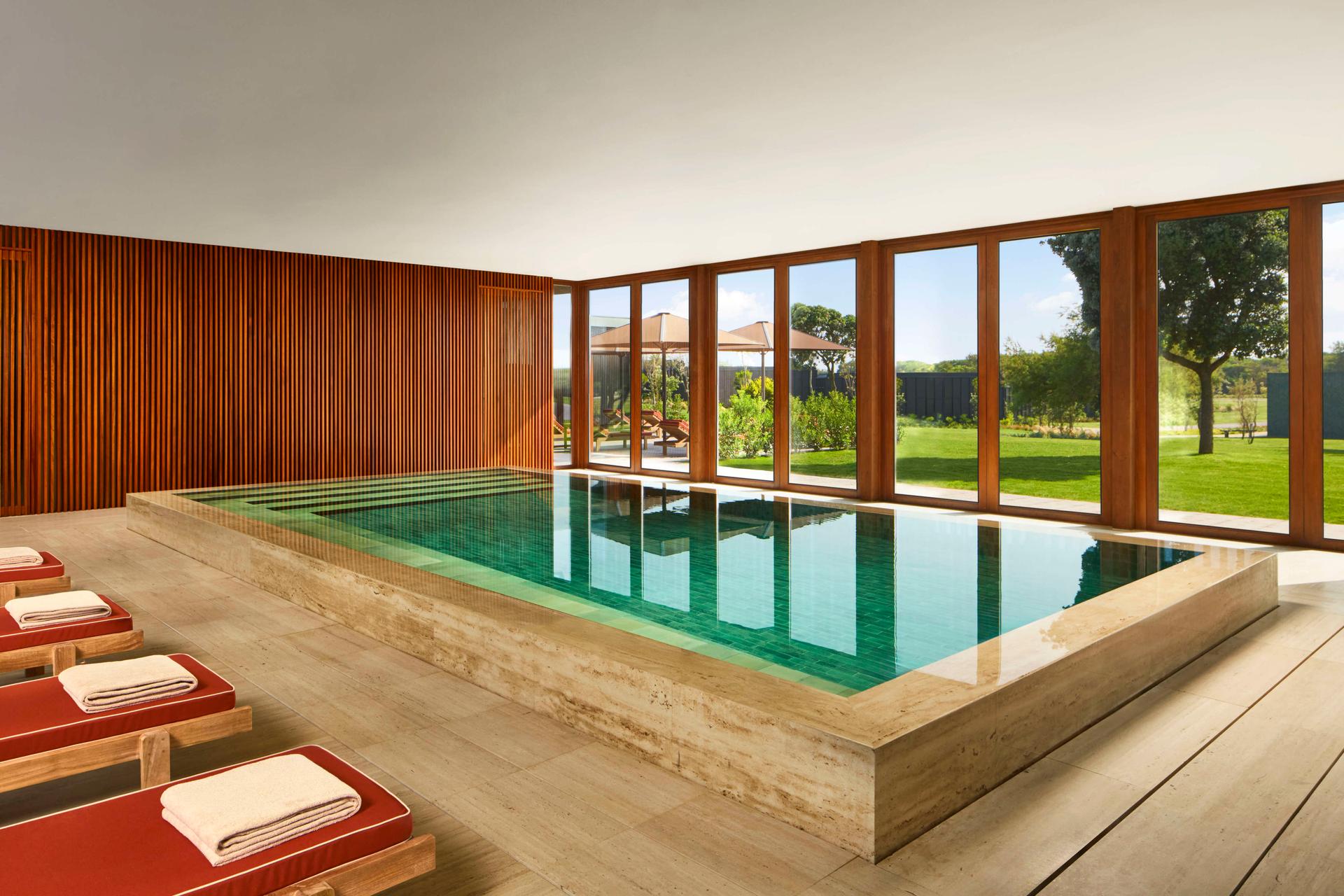 Indoor swimming pool next to sunbeds at Tivoli Estela Golf & Lodges Porto