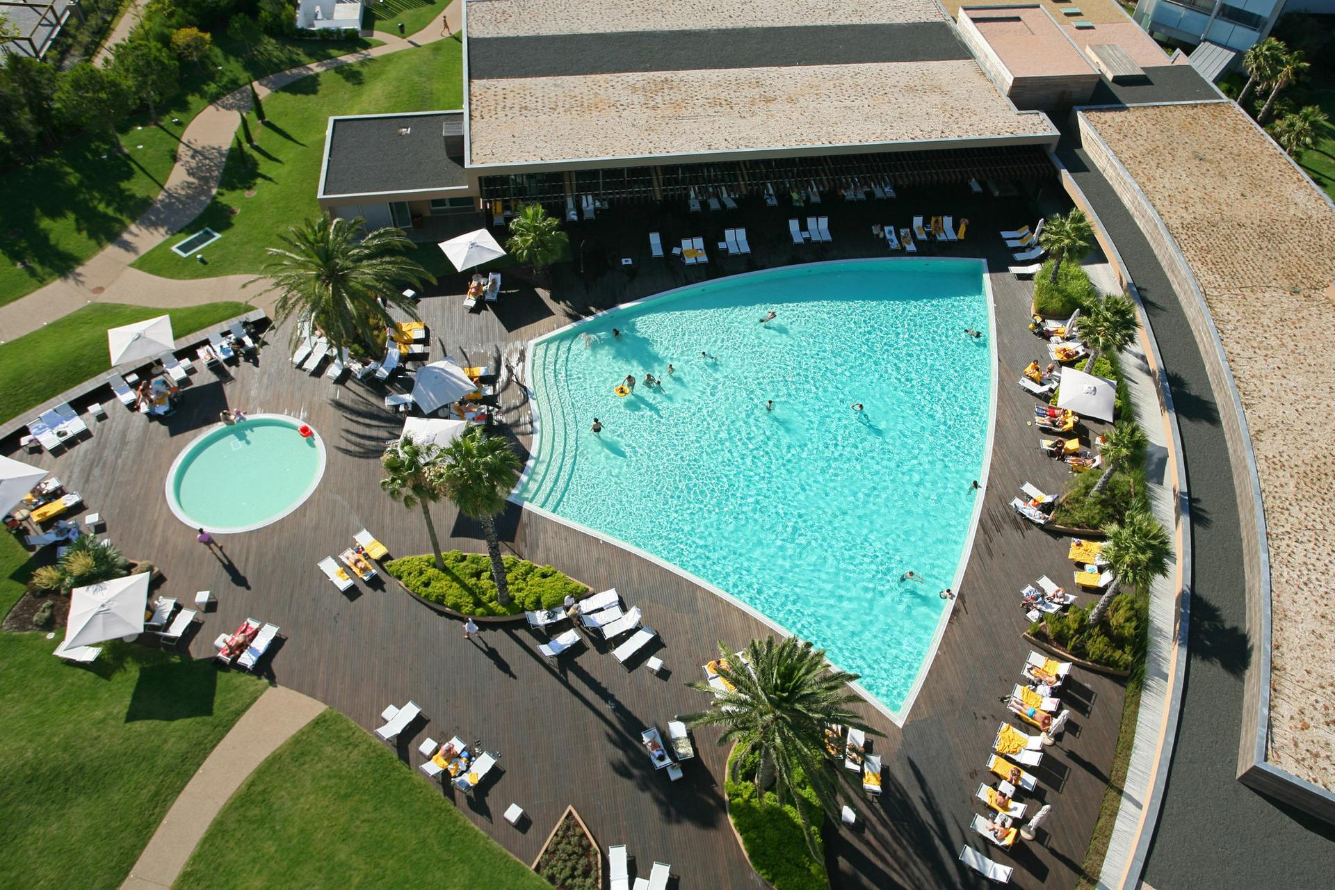 Overhead view of the outdoor swimming pool at Troia Resort - Aqualuz Suite Hotel Apartments