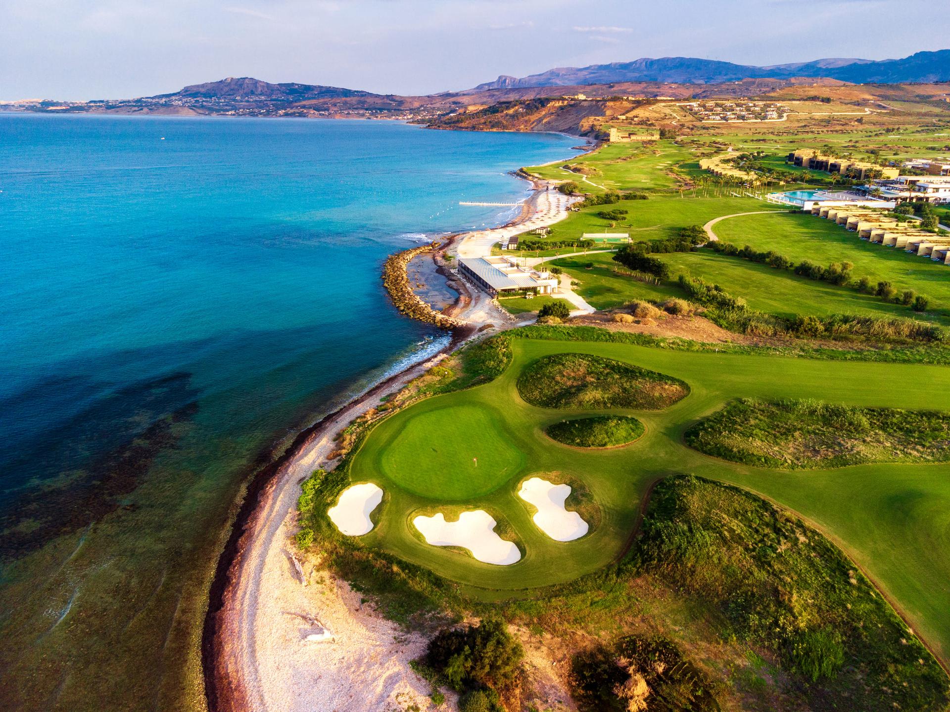 Overhead view of a well maintained fairway with a smooth green surrounded by sand bunkers