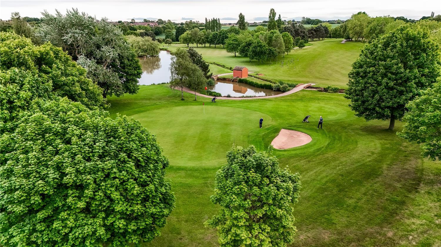 Overhead view of a smooth green next to a sand bunker