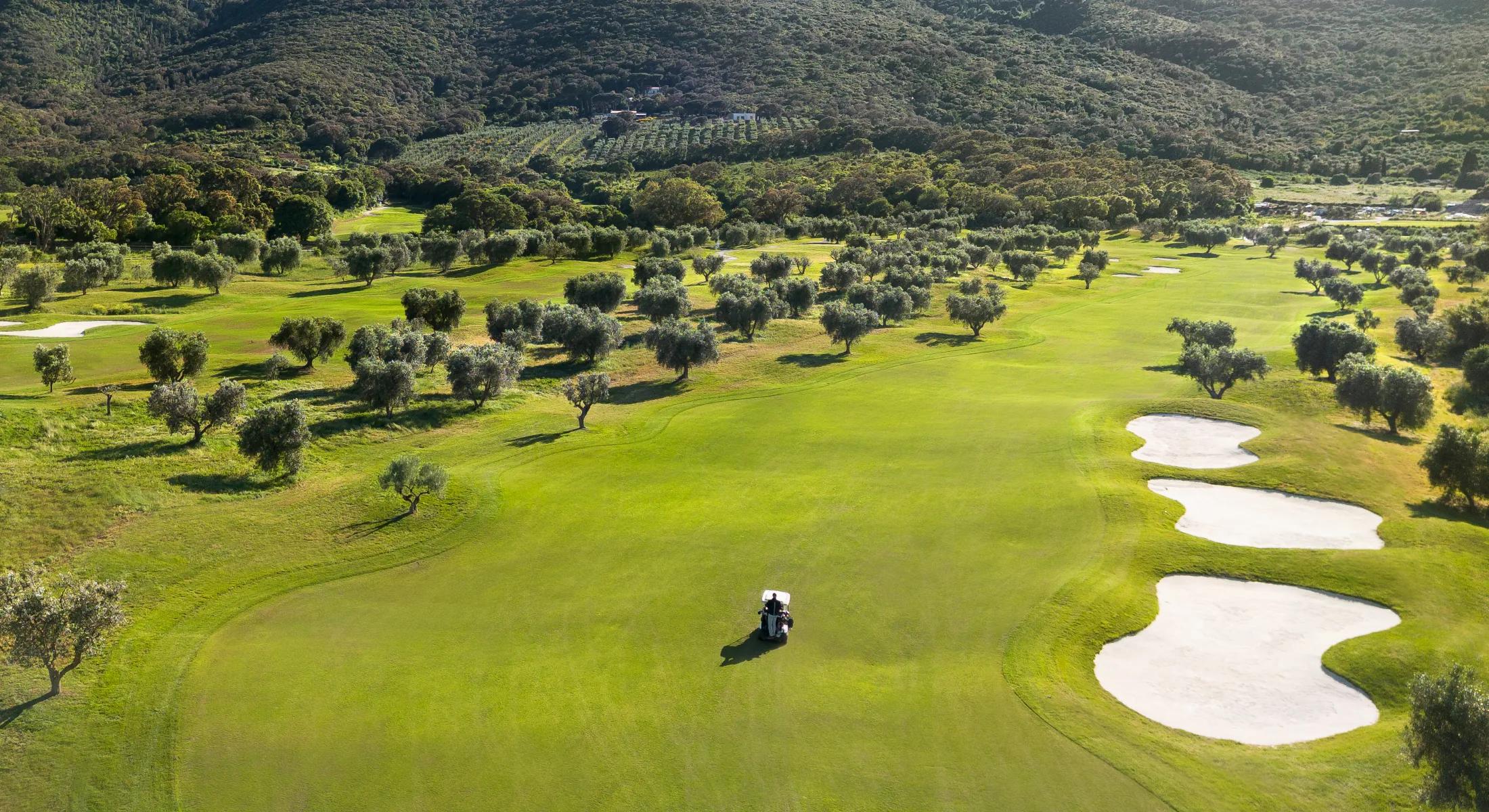 Overhead view of a well maintained fairway with sand bunkers and a buggy to navigate the course