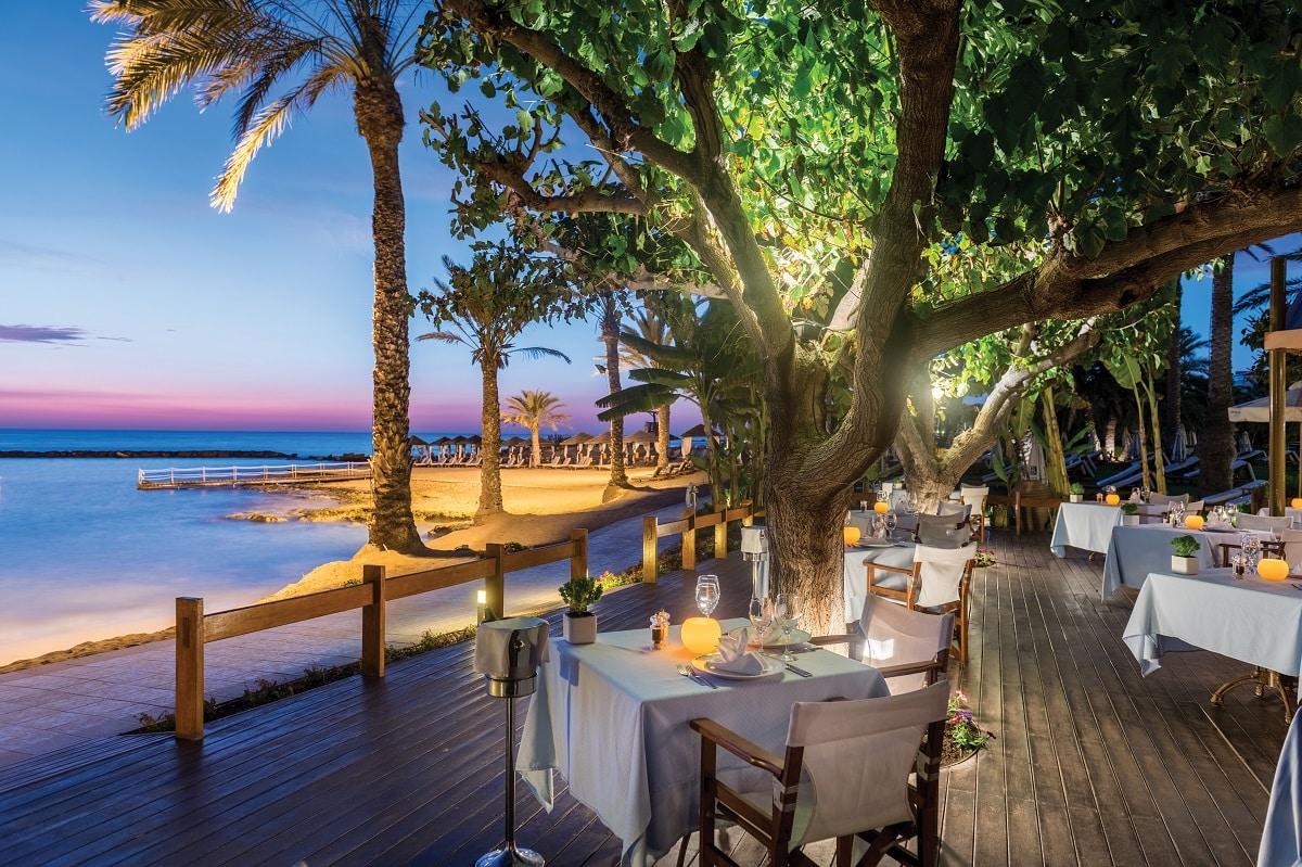Outdoor dining area at Constantinou Bros Asimina Suites Hotel with beach views