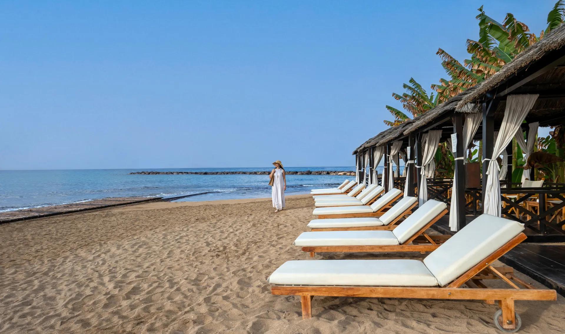 The beach at Constantinou Bros Asimina Suites Hotel lined with sunbeds