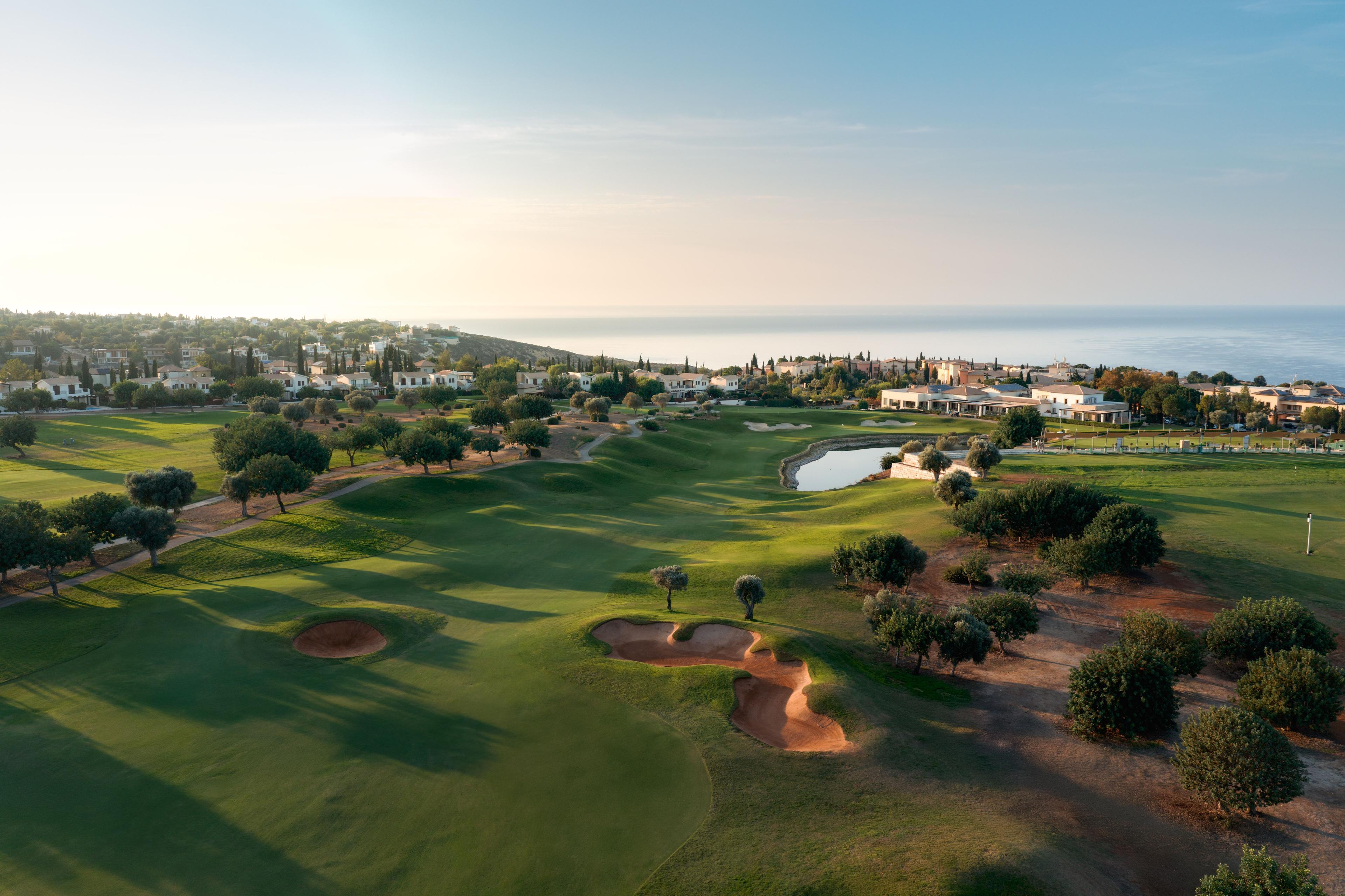 Overhead view of a well maintained fairway nestled with sand bunkers under clear blue skies
