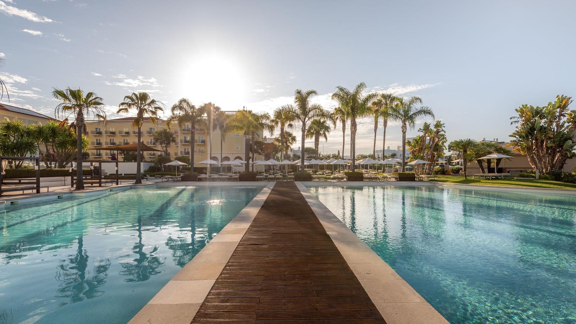 A walkway to navigate the outdoor swimming pool at Domes Lake Algarve, Autograph Collection