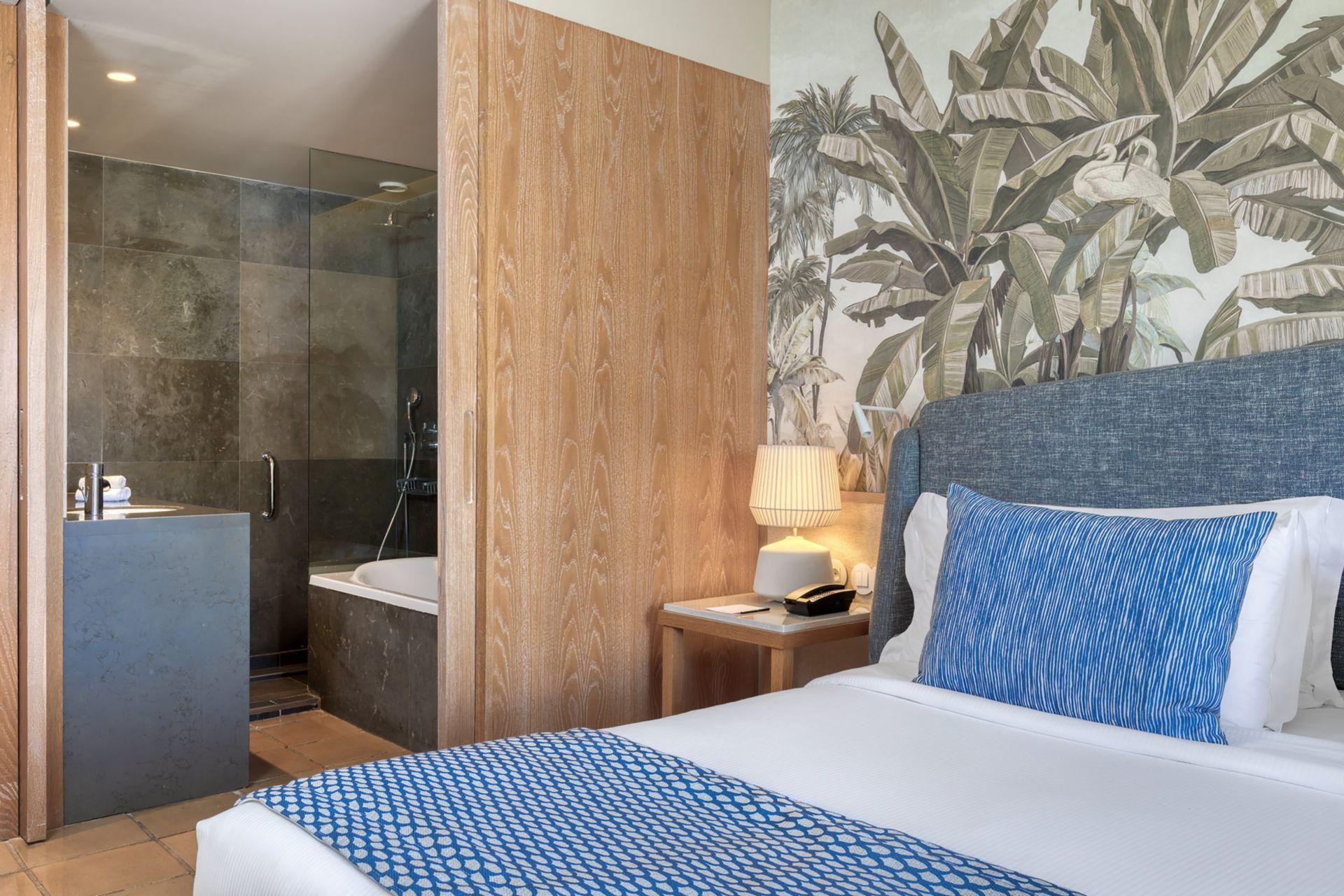 Bathroom and bed as part of a double bed suite at Domes Lake Algarve, Autograph Collection