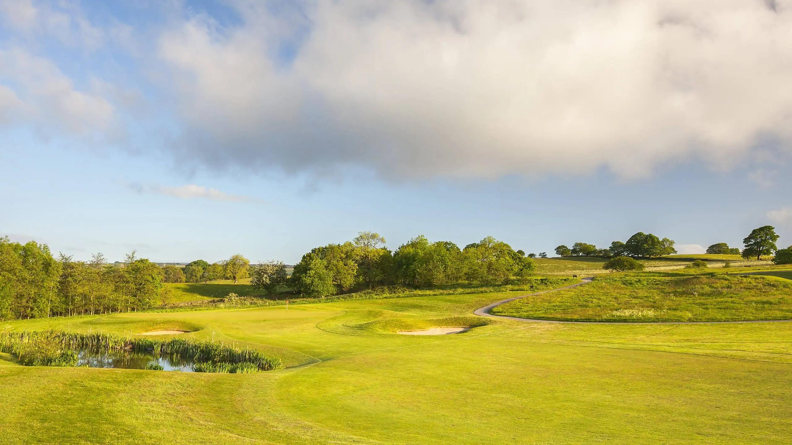 A well maintained fairway nestled with sand bunker