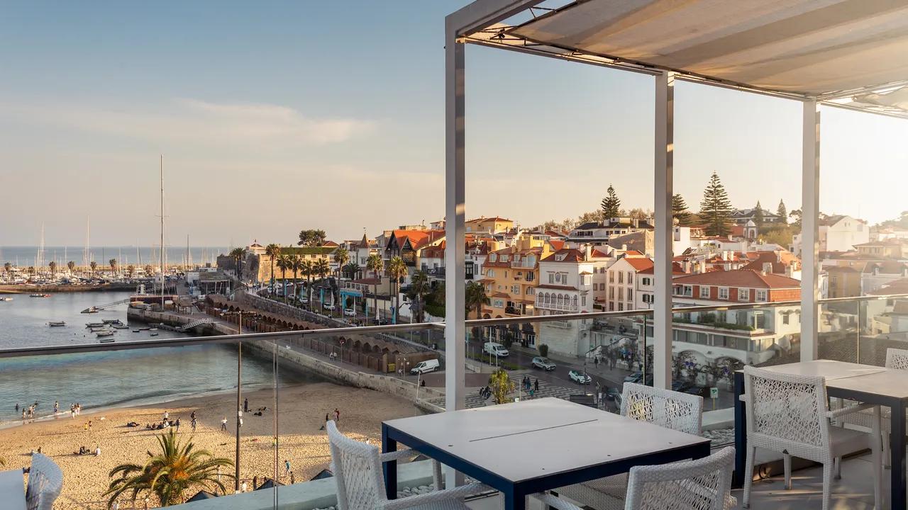Rooftop lounging area with beach views at Hotel Baia