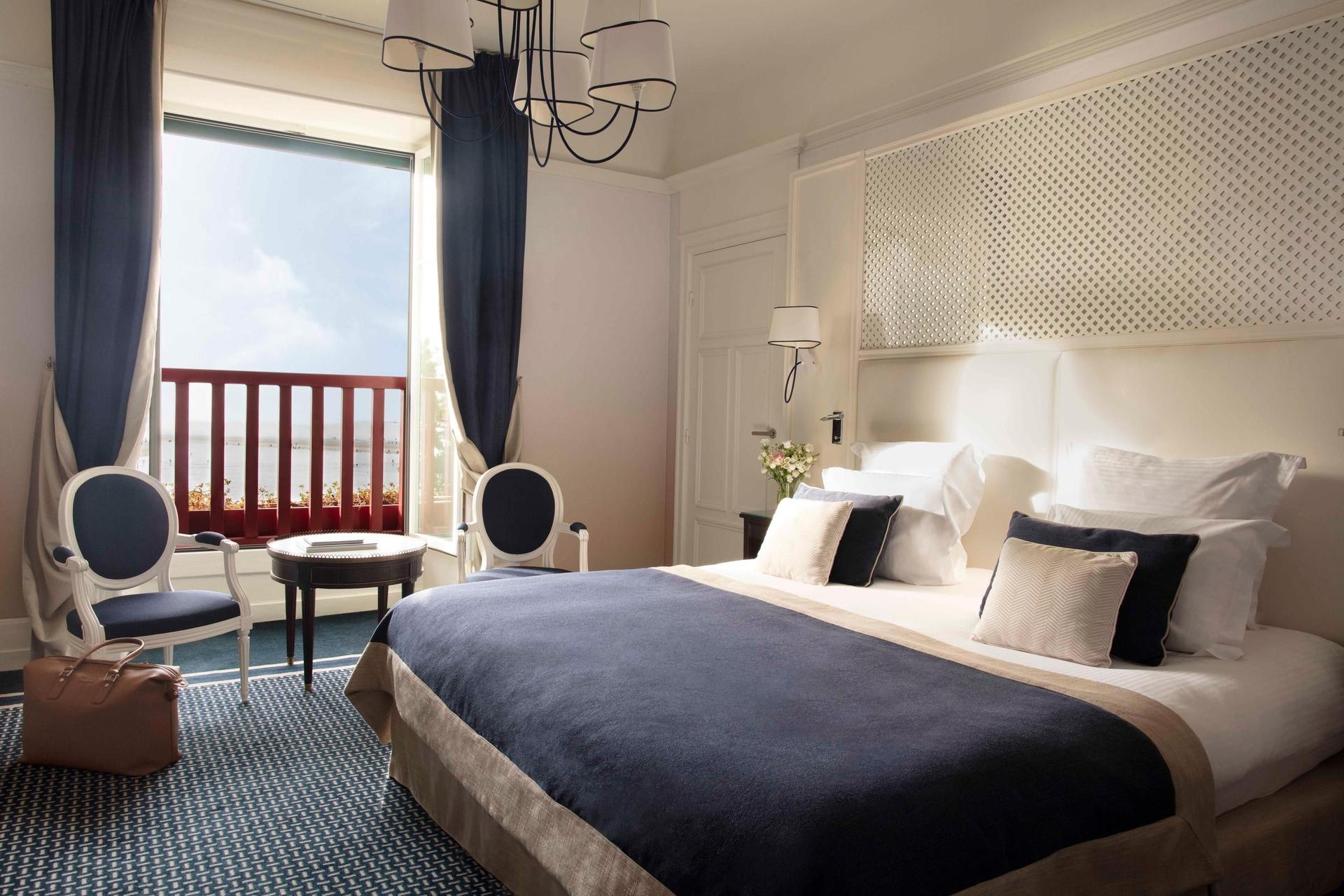 Luxurious double bed suite at Hotel Barriere L'Hermitage La Baule with balcony views of the beach