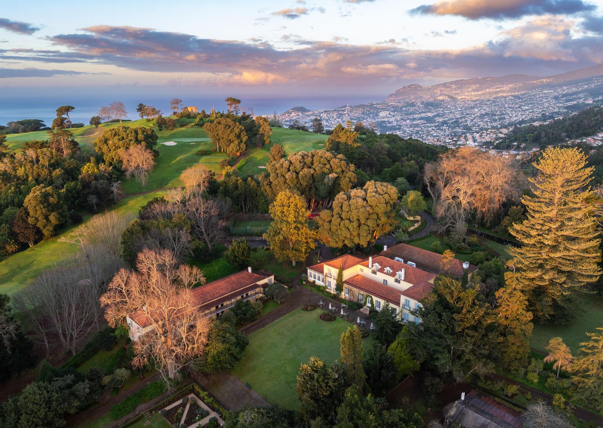 Aerial view of the coastal Hotel Casa Velha do Palheiro - Relais & Chateaux with its golf course in the background