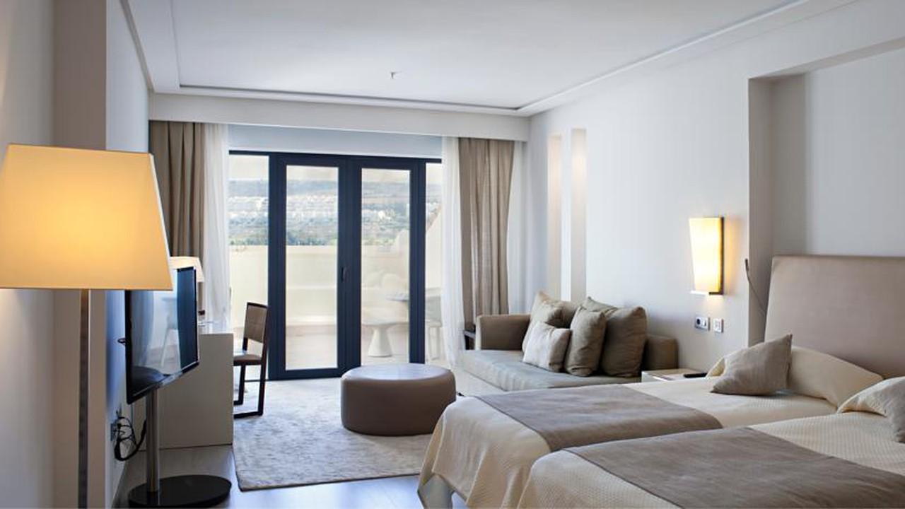 Spacious double bed suite with lounging area at Hotel Golf Almerimar