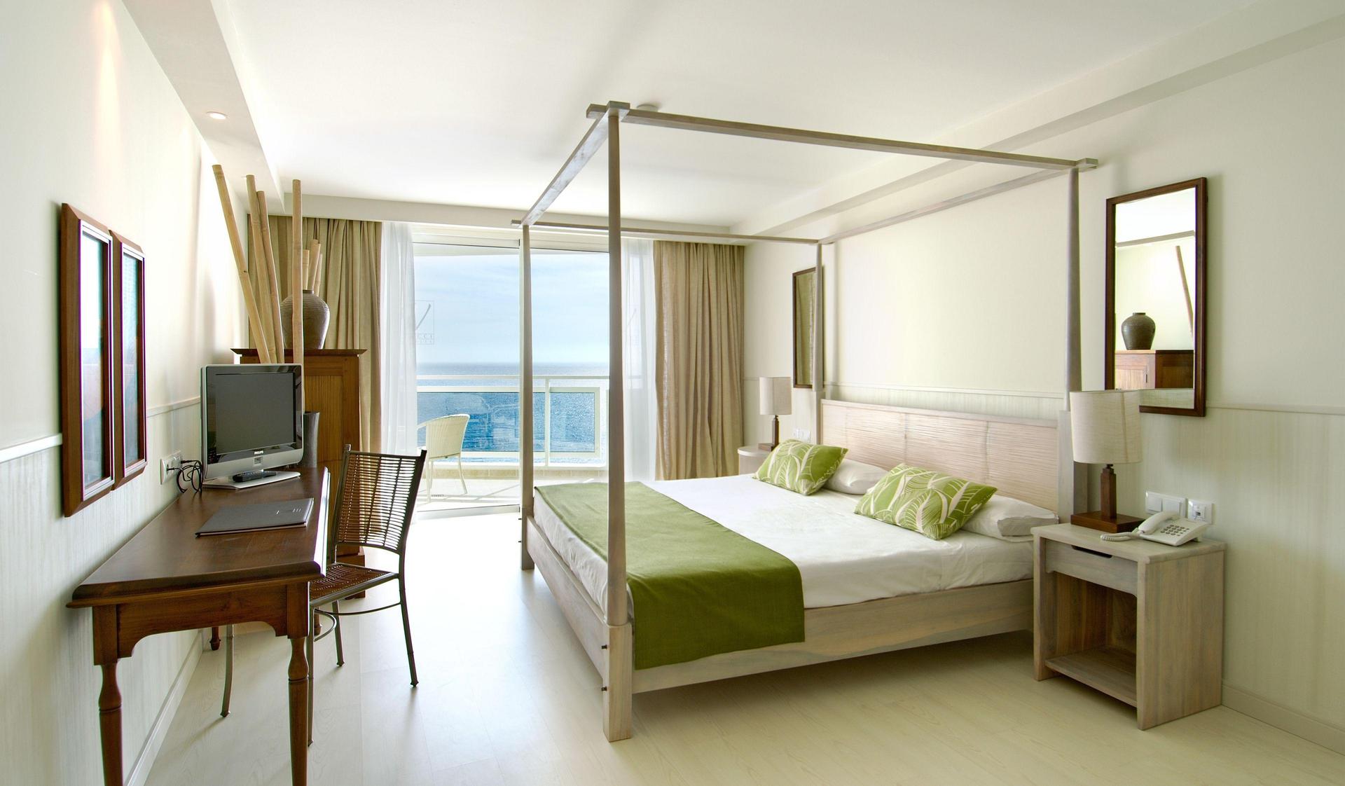 Spacious double bed suite with balcony views of the sea