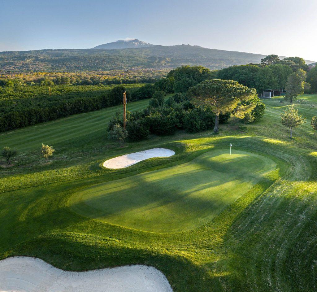 A manicured green surrounded by sand bunkers