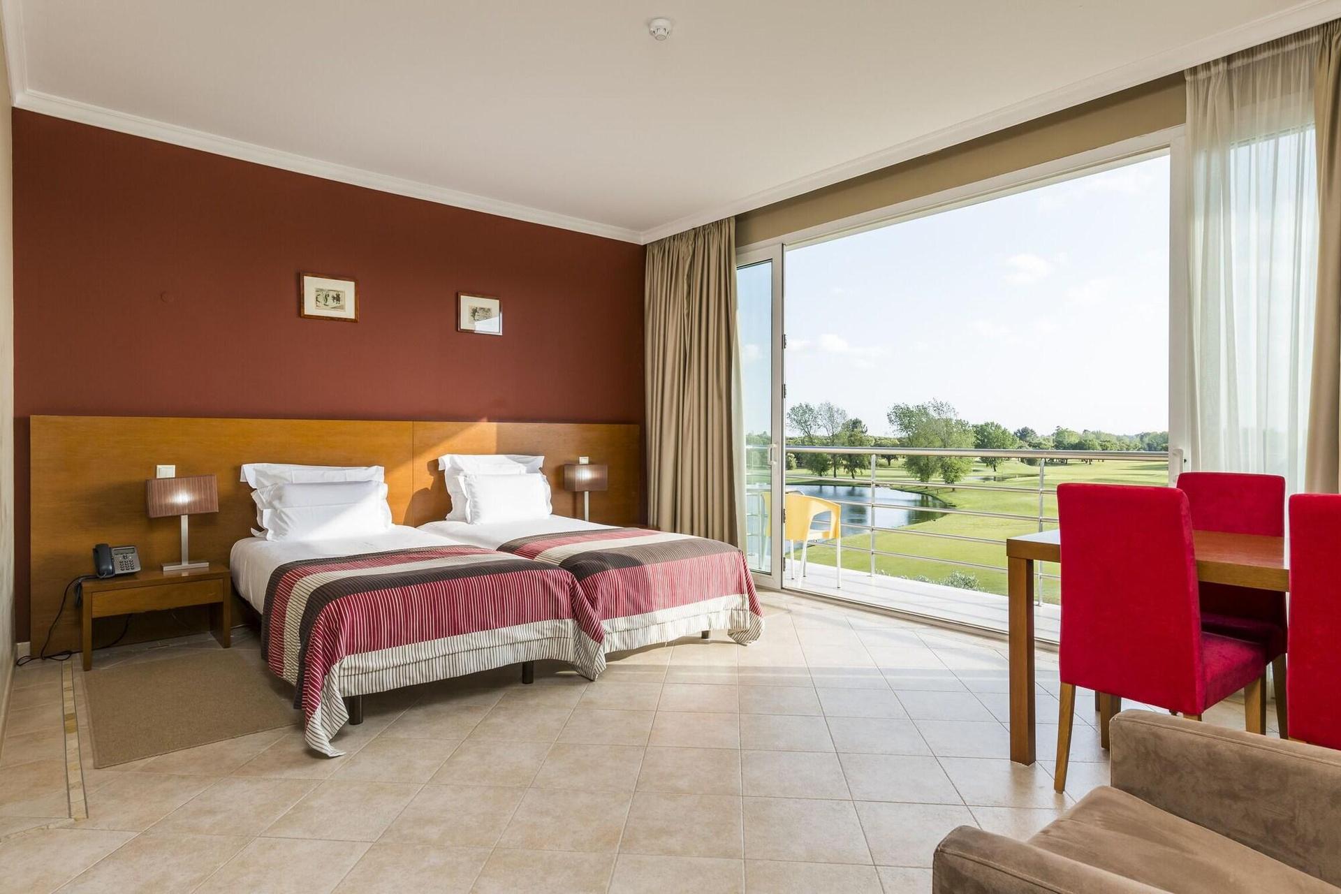 Spacious double bed room with balcony views of the golf course at Montado Hotel & Golf Resort