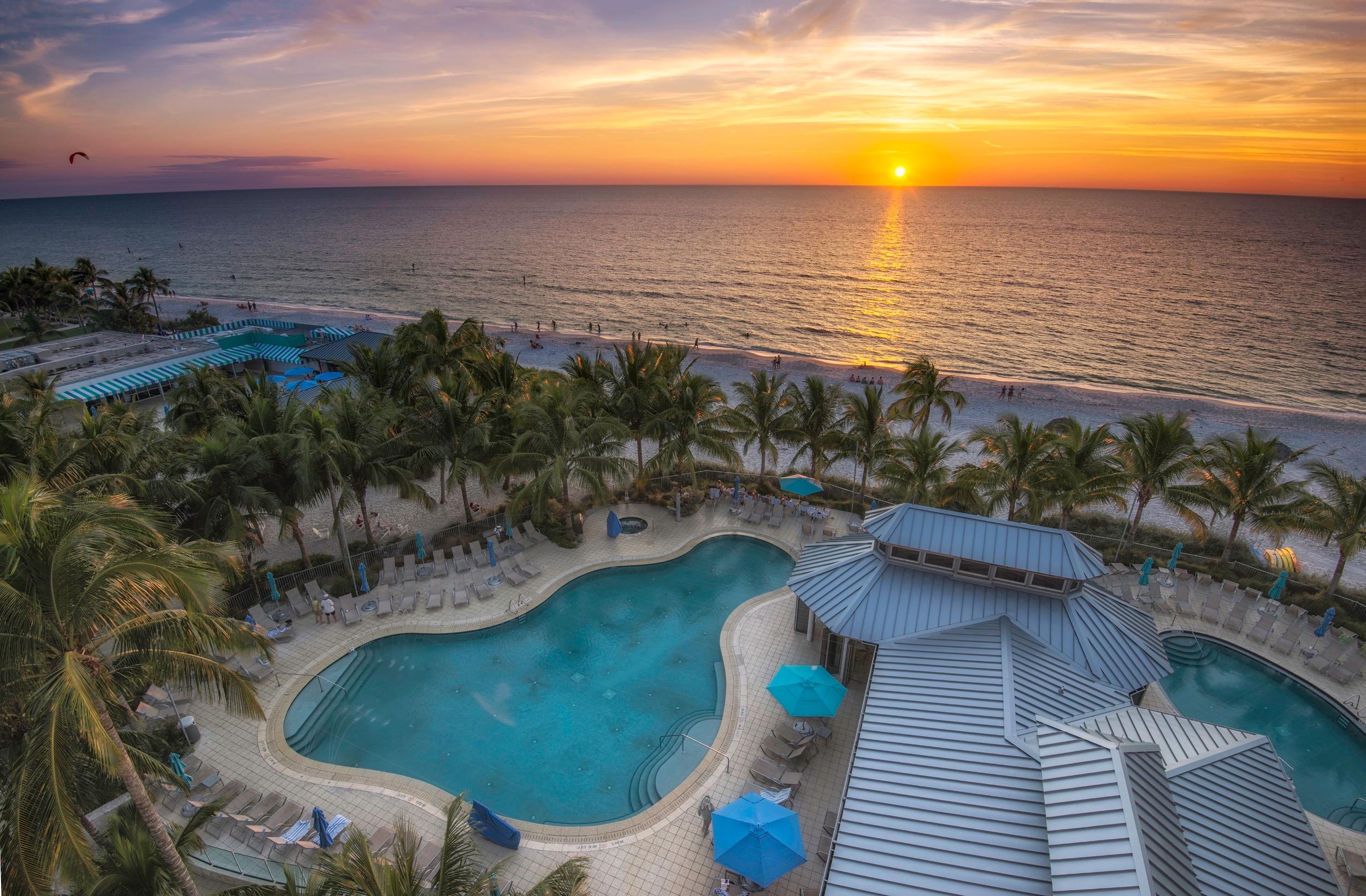 Sun setting over the outdoor swimming pool at Naples Beach Hotel and Golf Club