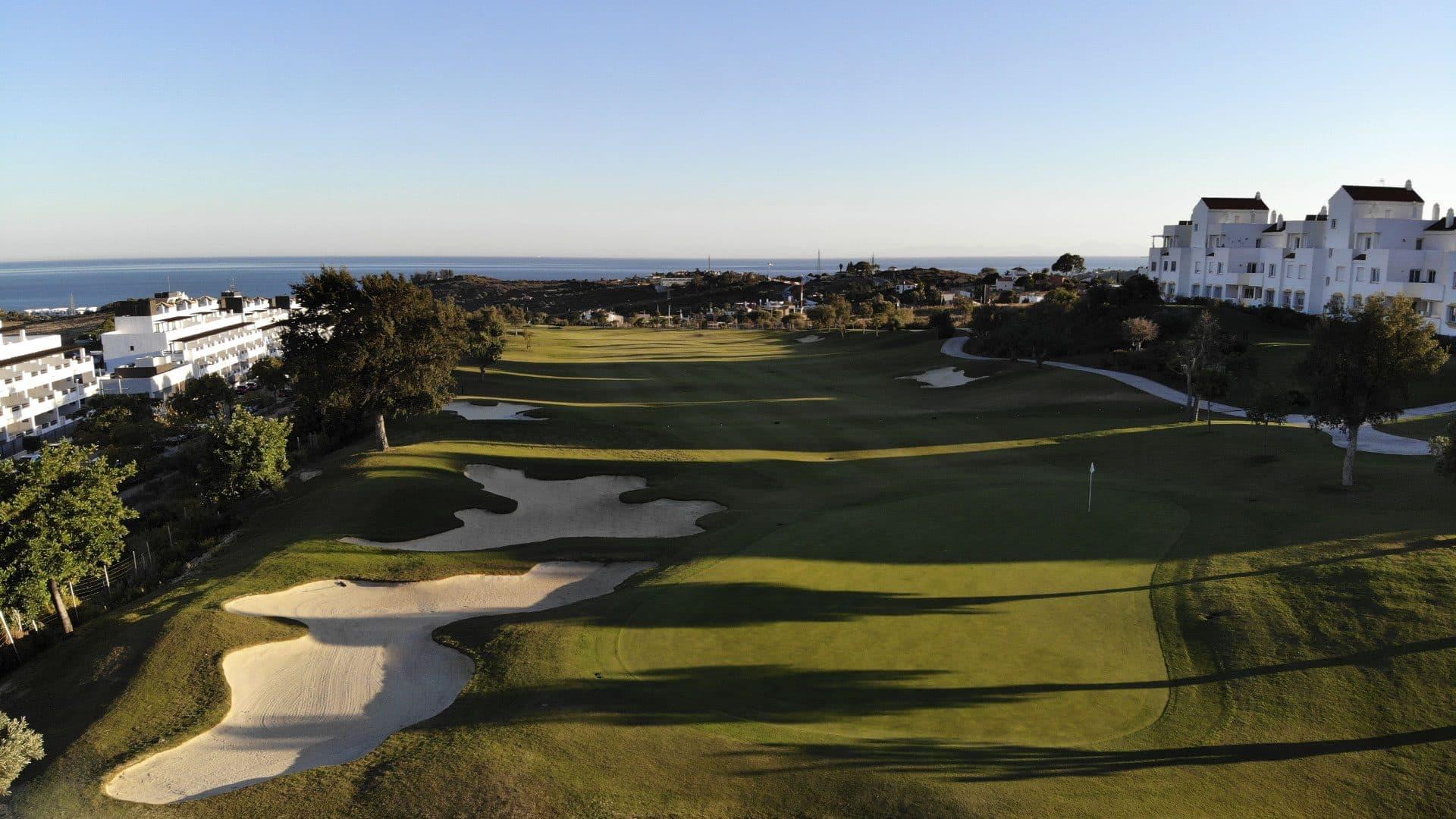 Overhead view of a well maintained fairway riddled with sand bunkers