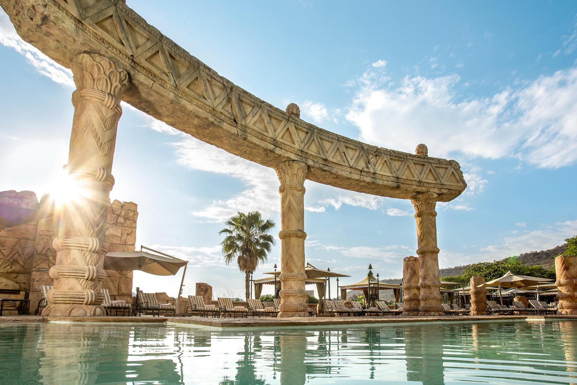 Outdoor swimming pools surrounded by ancient stones at Sun City Resort, The Palace of the Lost City
