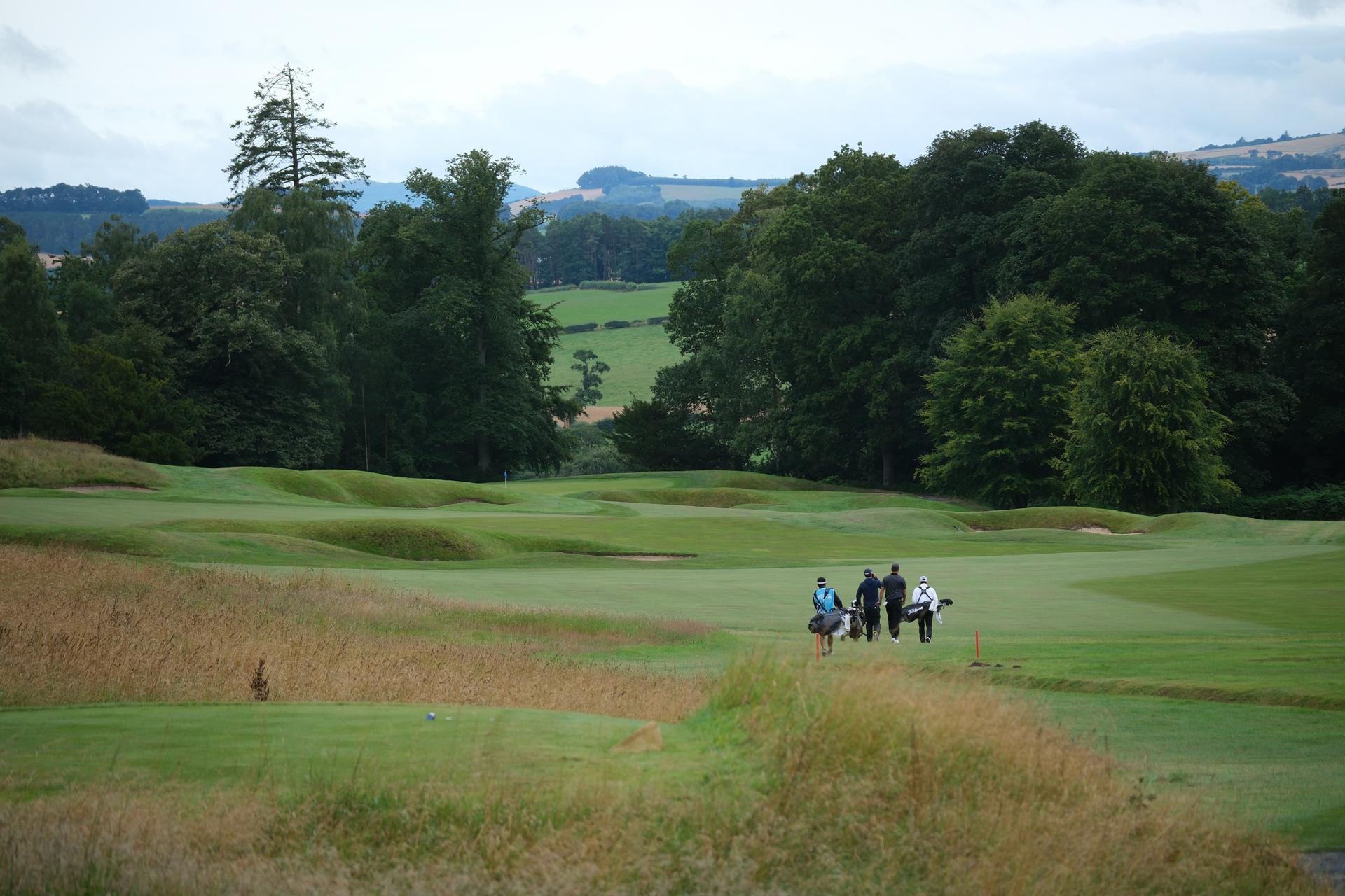Golfers walking down a well maintained fairway
