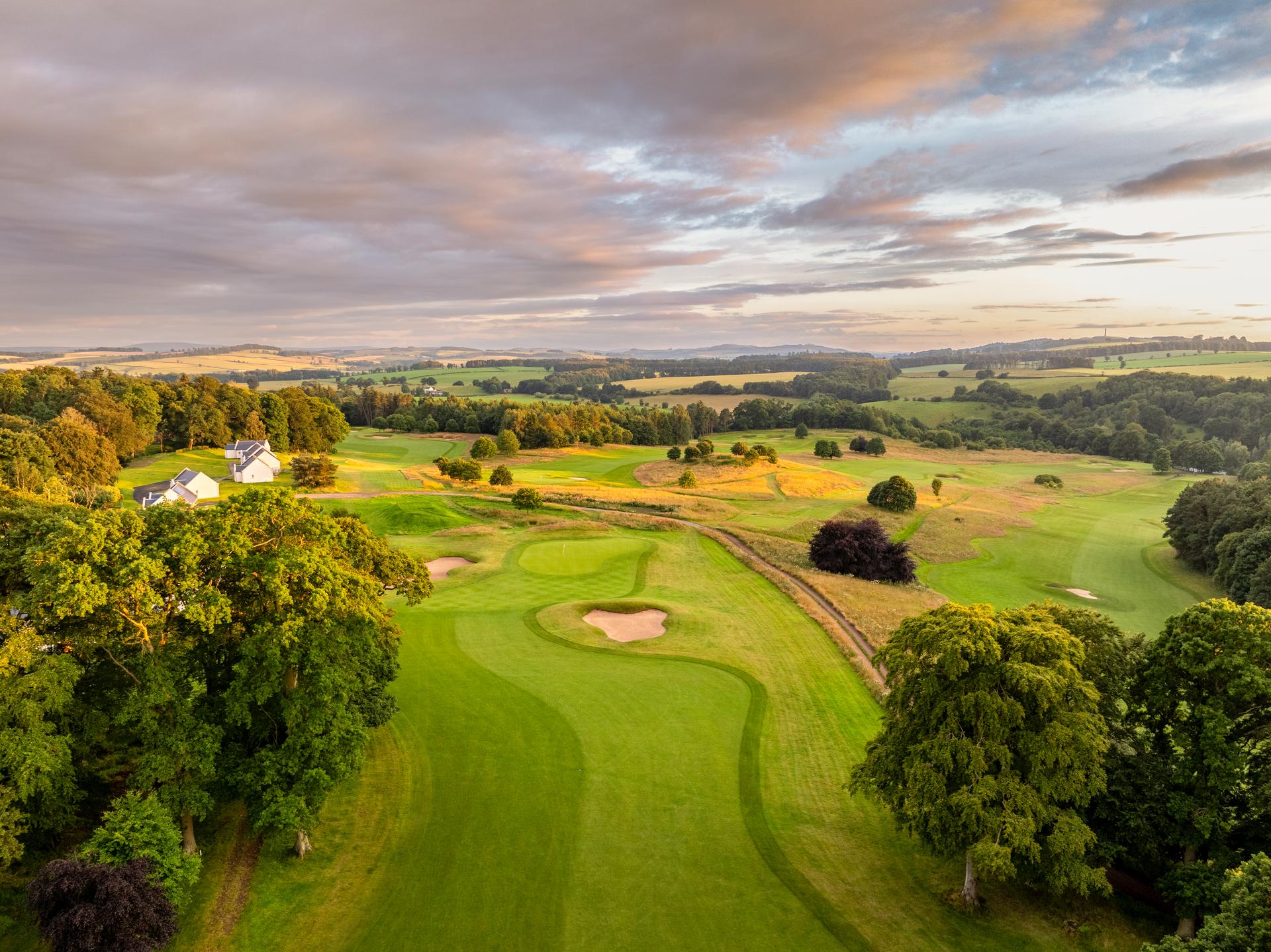 A well maintained fairway nestled with a sand bunker